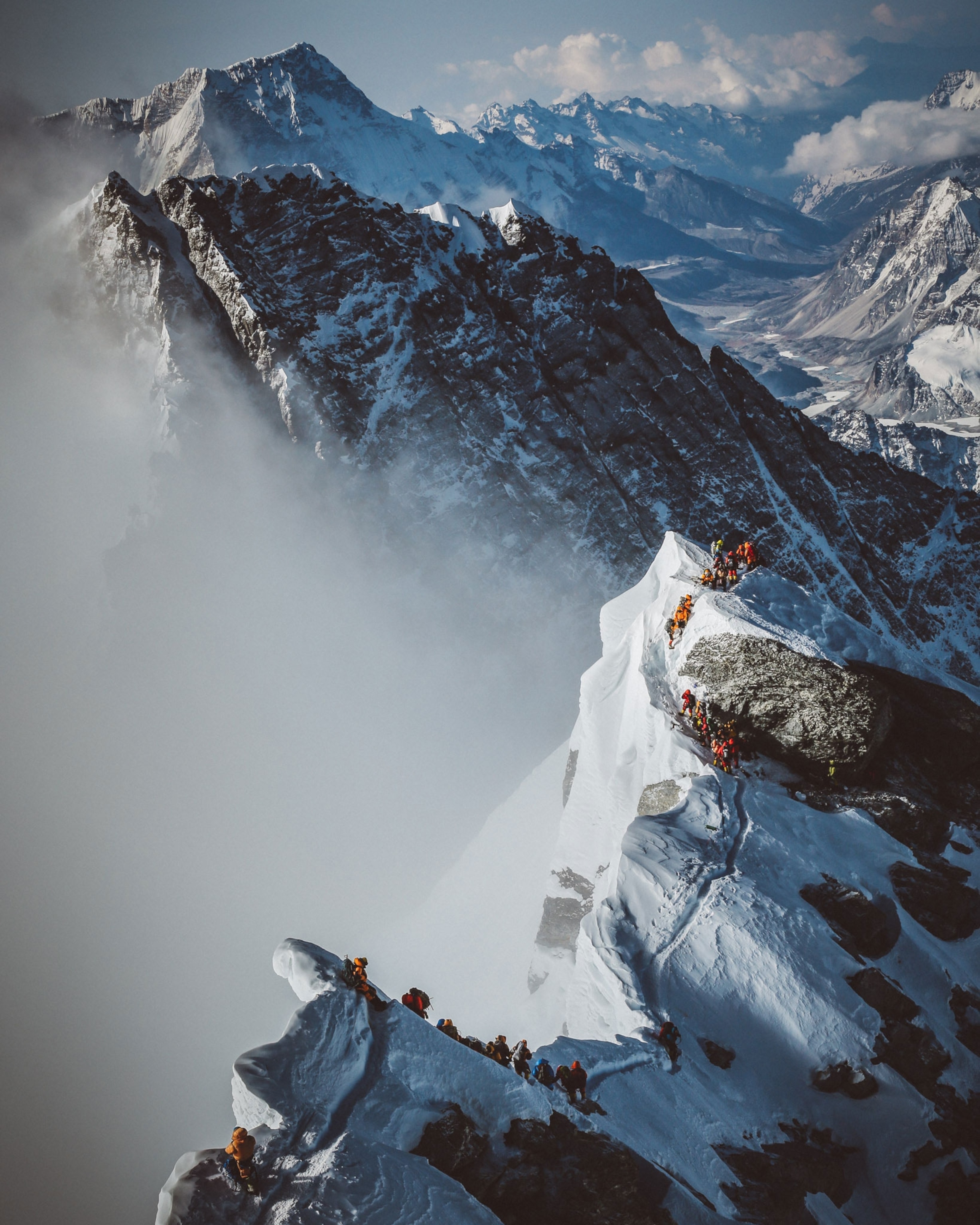 crowds of people ascending to the summit of Mount Everest