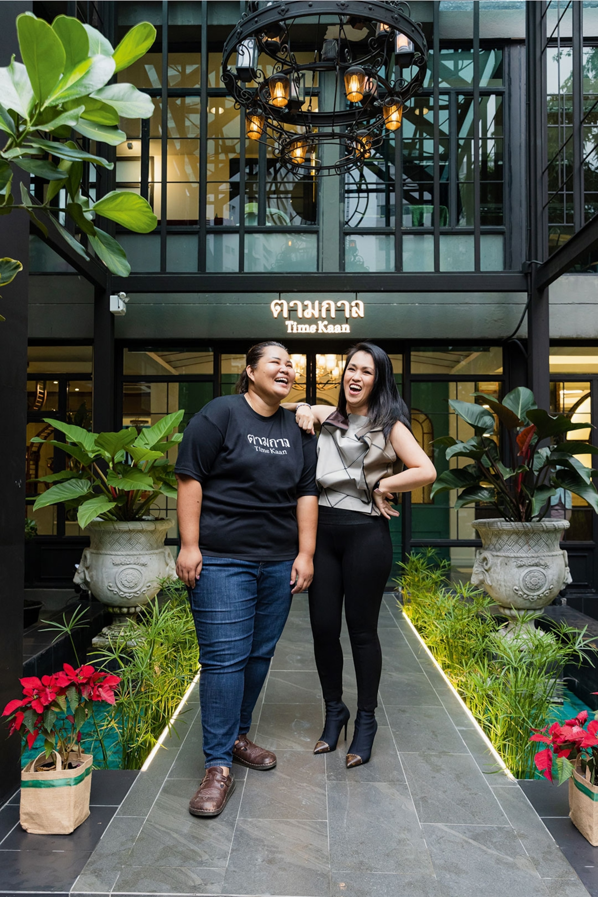 Two women standing in front of a restaurant.