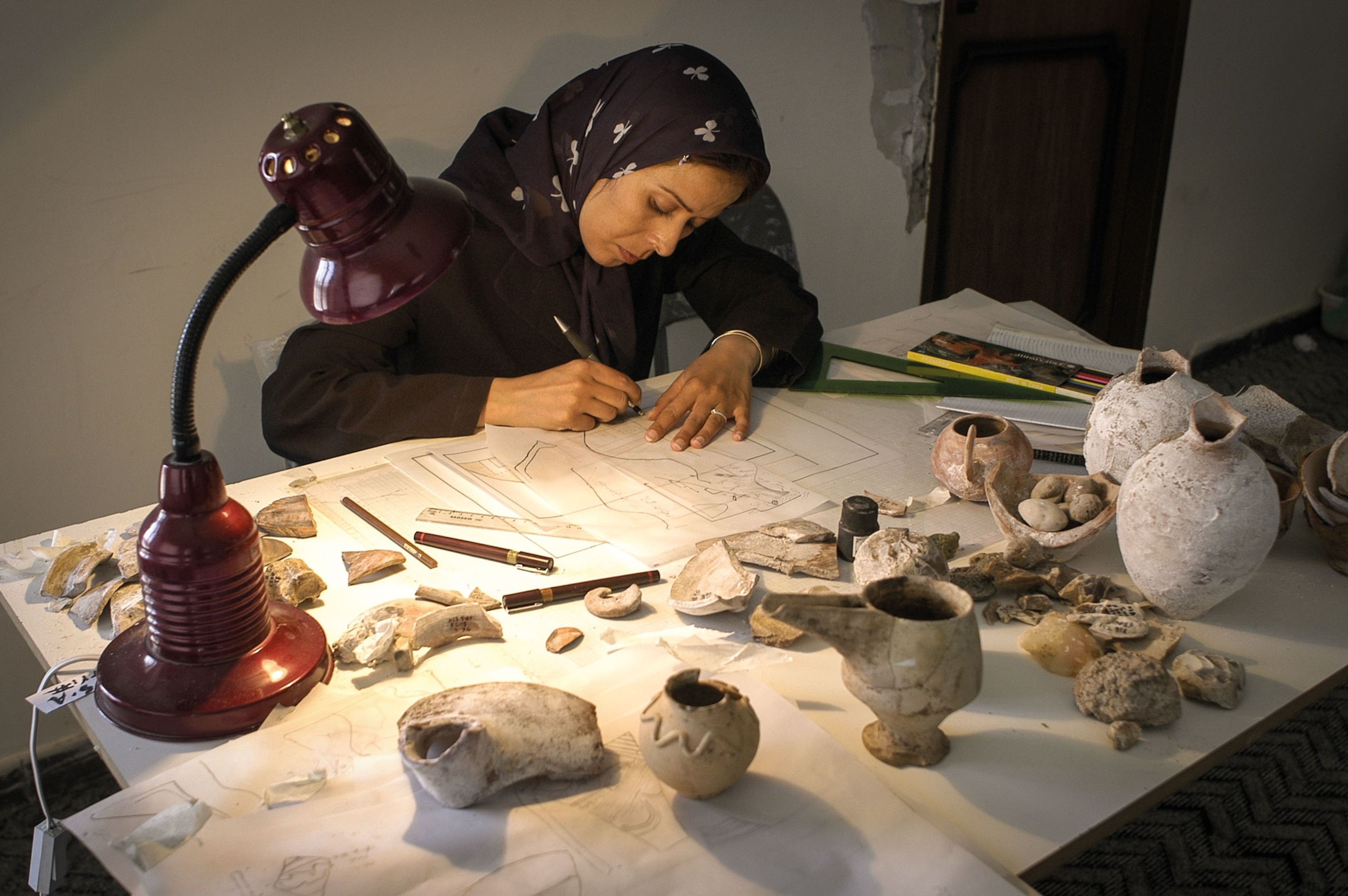 A woman looks at artifacts on a table