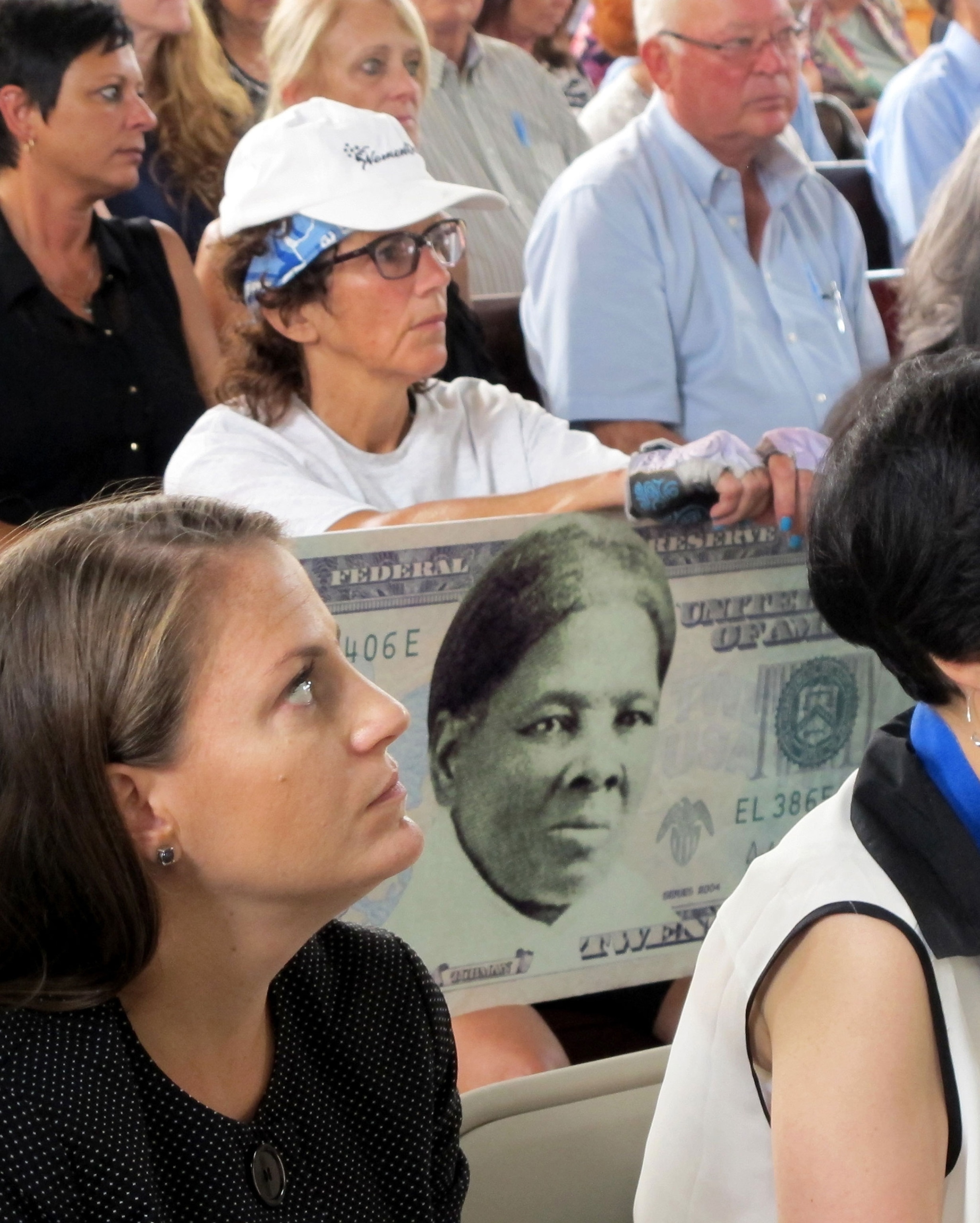 a woman holds a sign supporting Harriet Tubman for the $20 bill