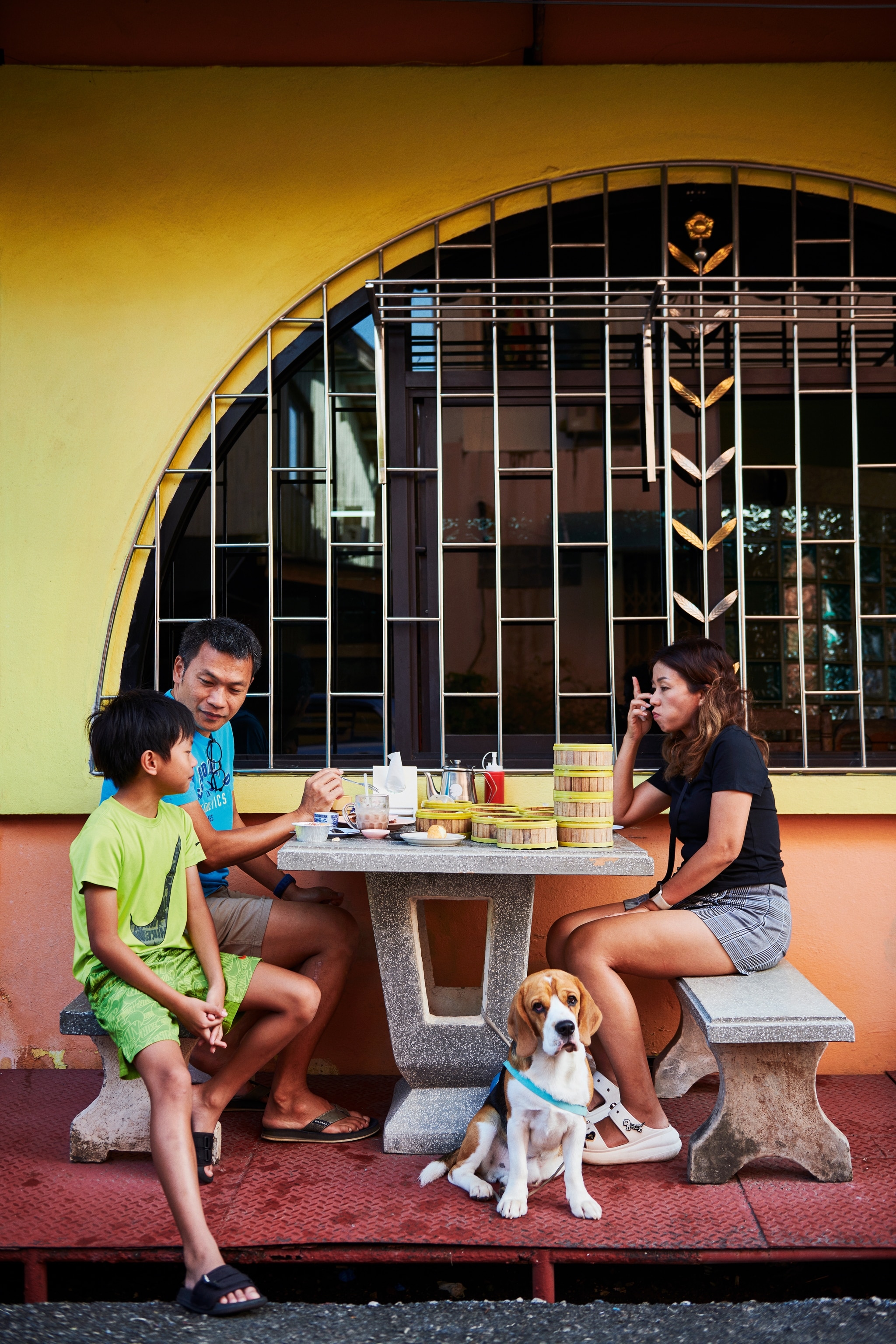 family eating dim sum in thailand sitting at outdoor table