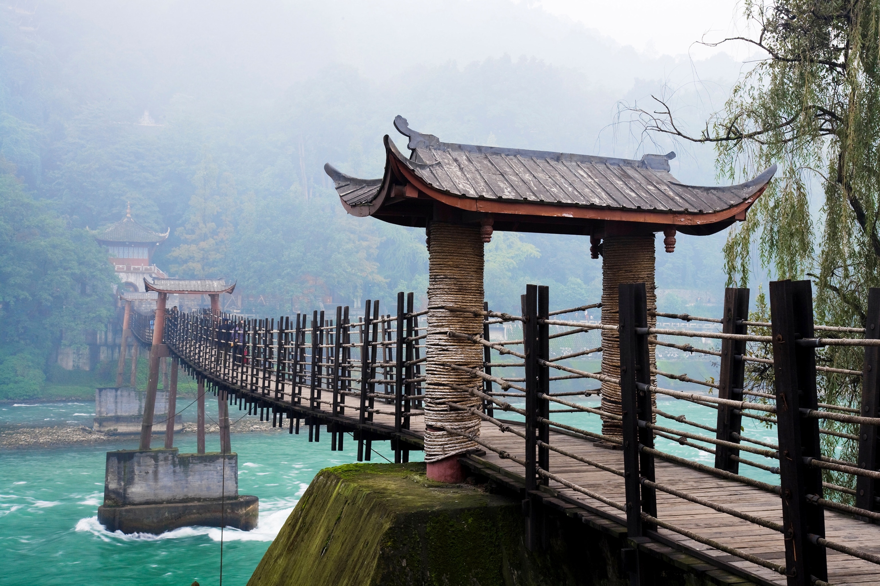 a suspension bridge over a river on Mount Qingcheng in China