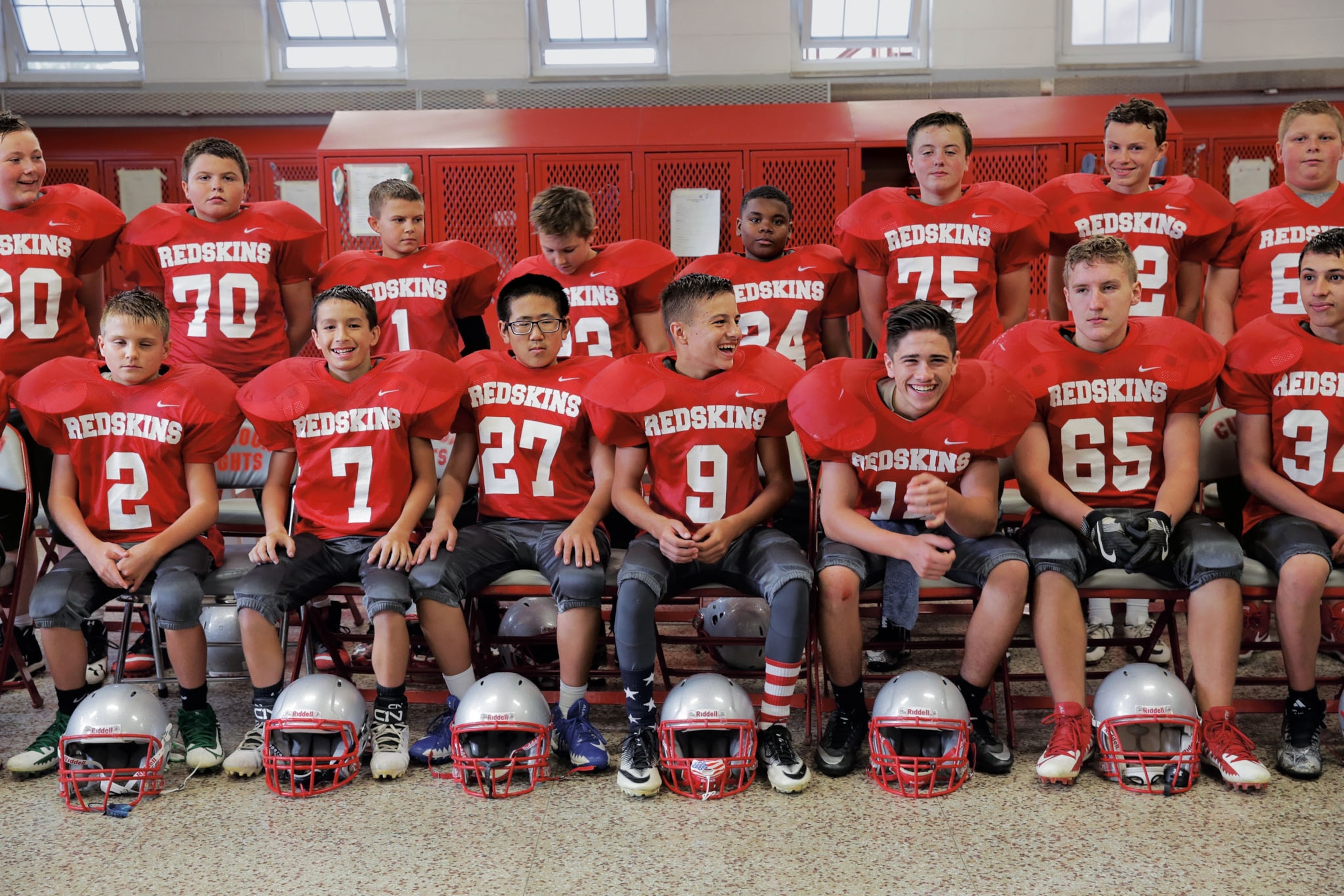 young boys posing for a portrait dressed in red football uniforms