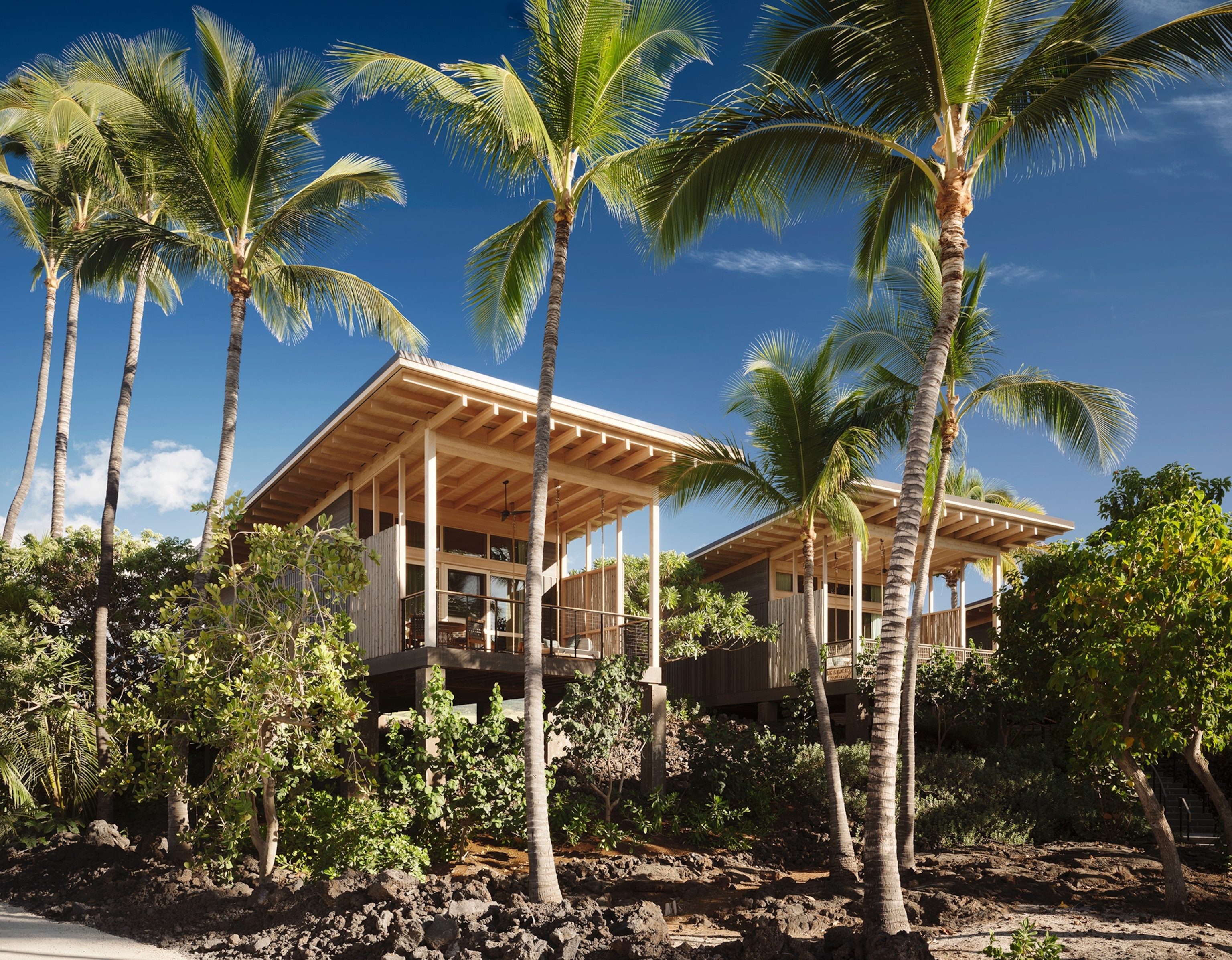 A hotel room surrounded by palm trees at the Rosewood Kona Village.