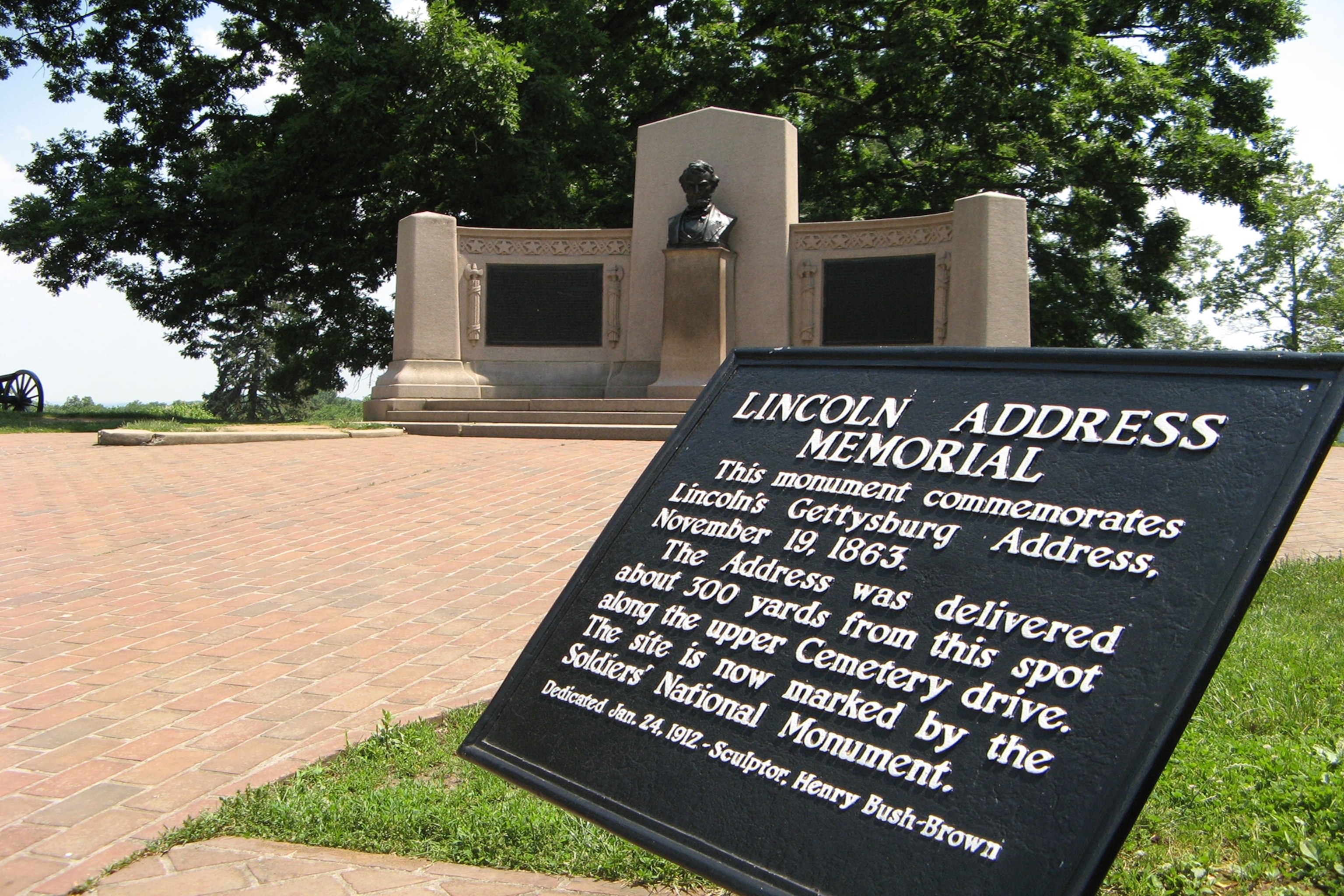 A memorial commemorating Lincoln's Gettysburg Address stands in front of a monument in Gettysburg.