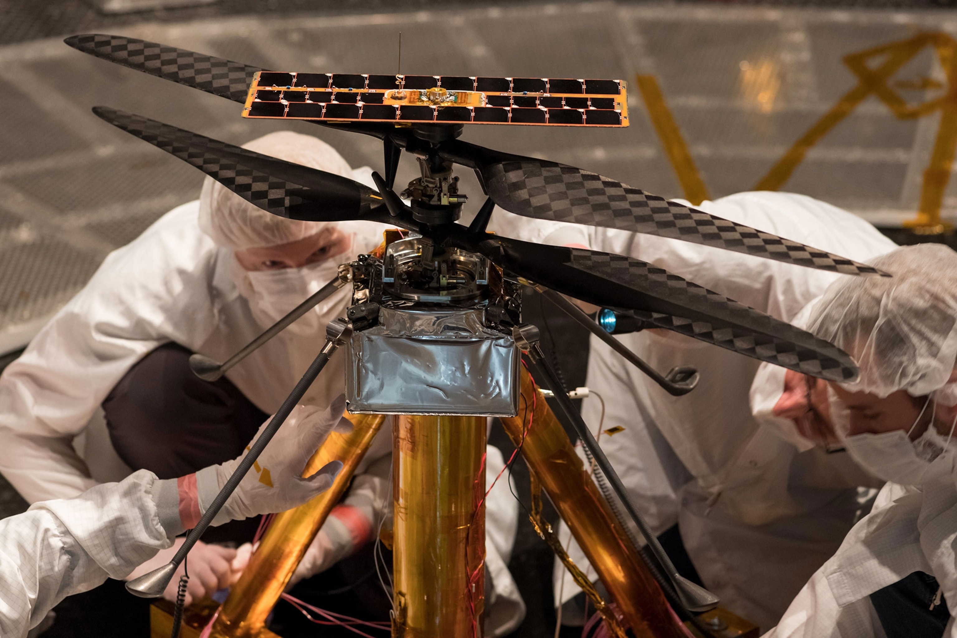NASA Mars Helicopter team inspects the aircraft.