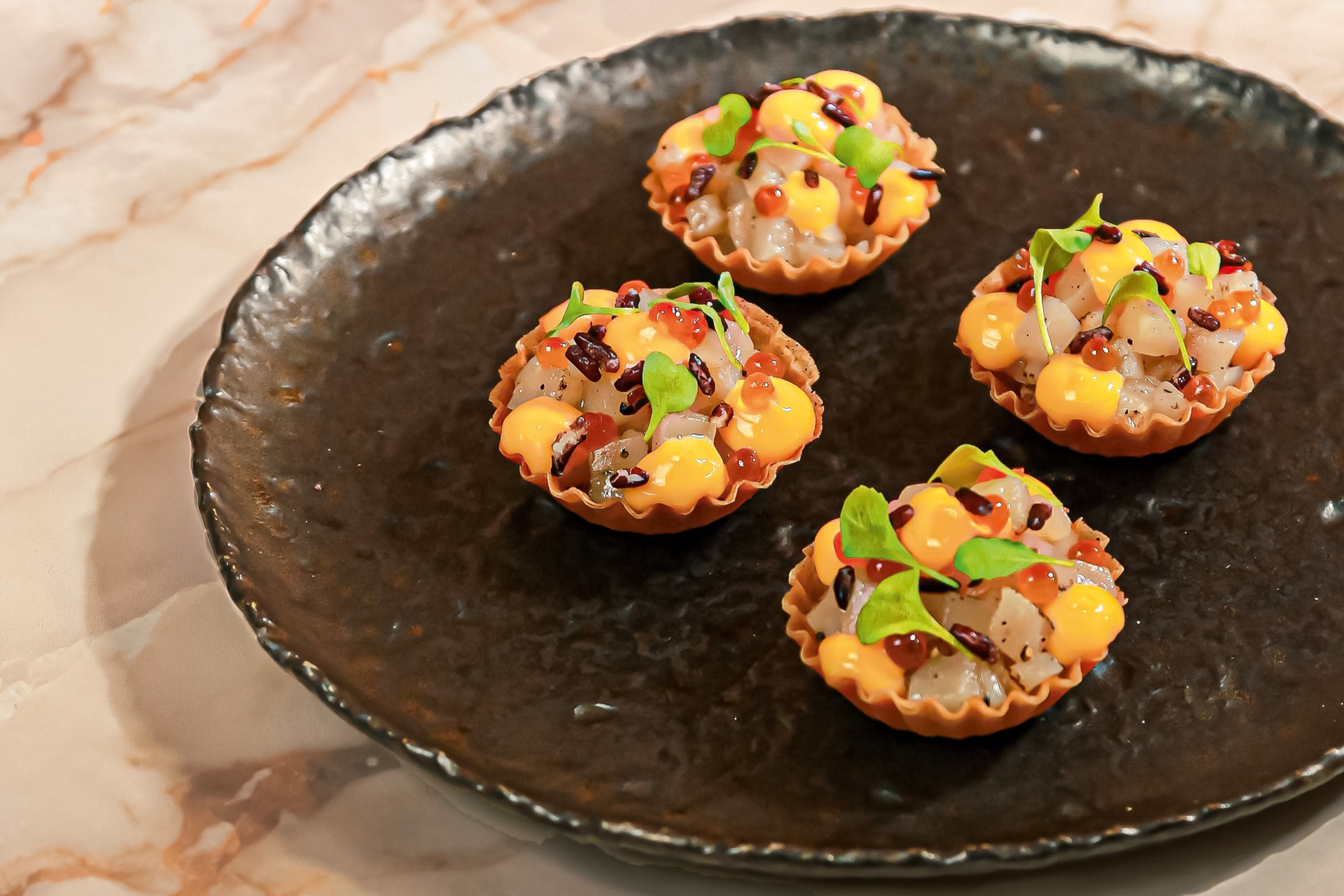 Small tarts serves on a plate garnished with leaves