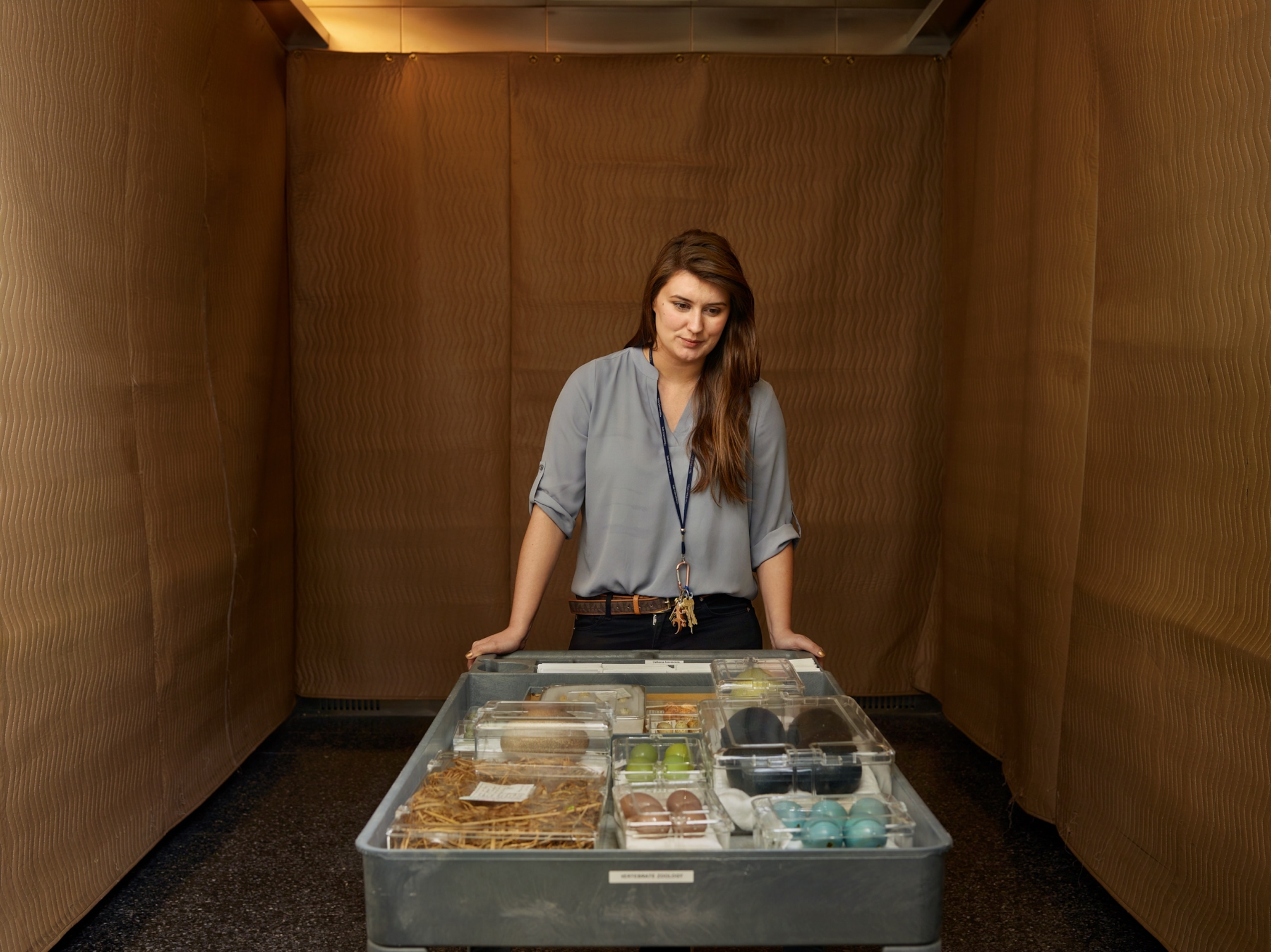 a woman standing over a cart with egg specimens