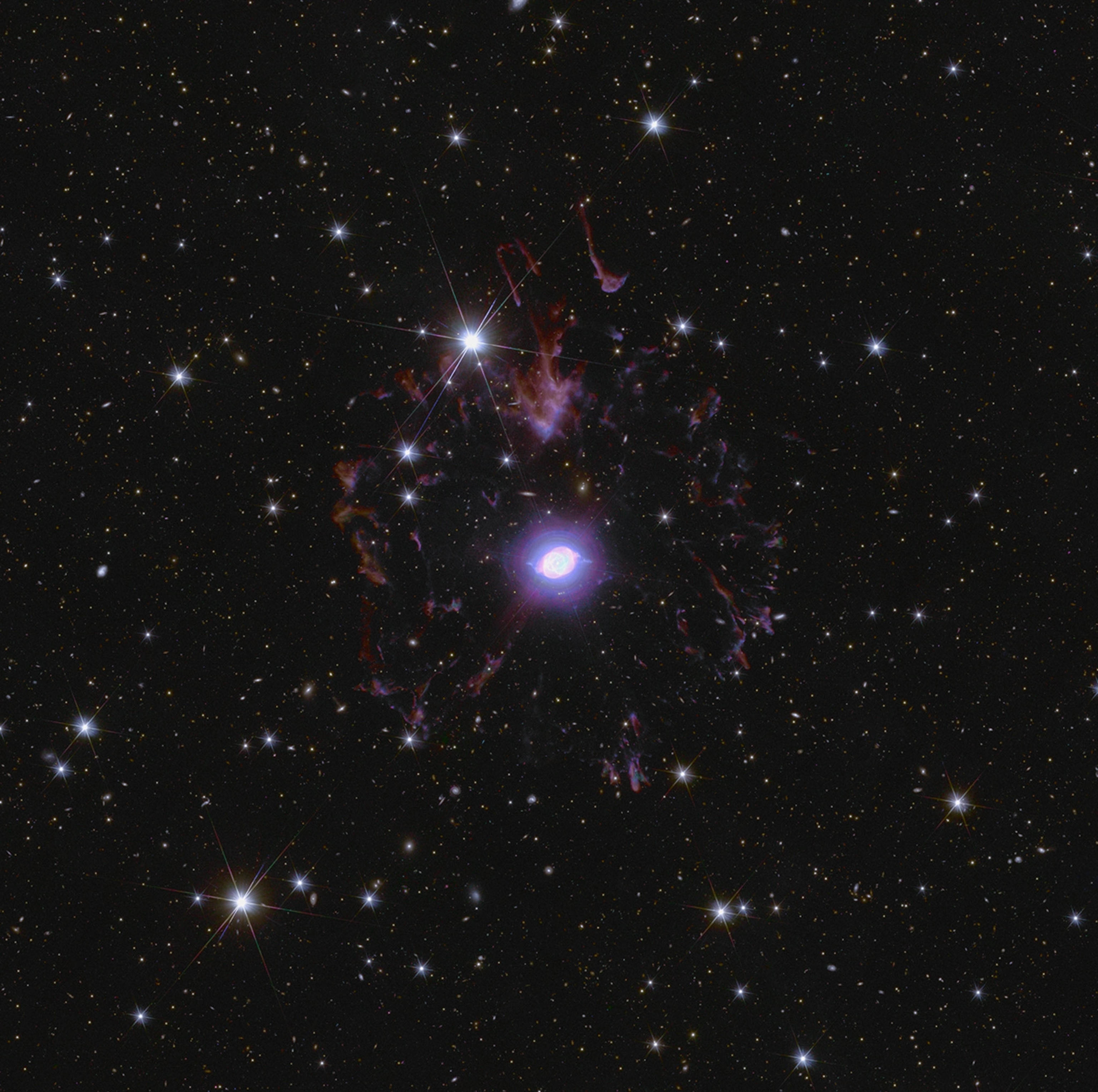 a black background covered with tons of bright white stars and some wispy purple clouds in the center