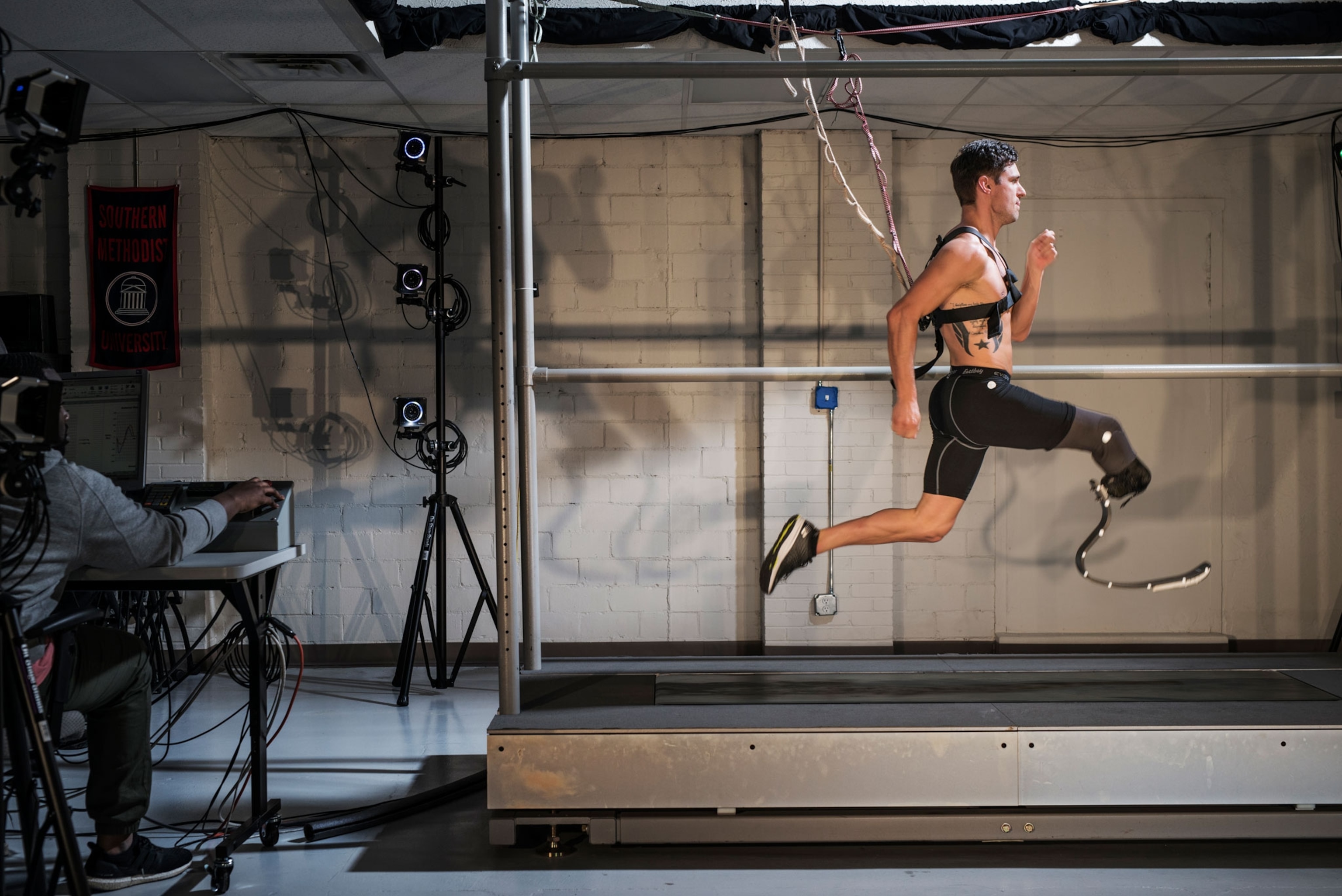 a man runs on a treadmill while hooked up to machines that read his bio mechanics