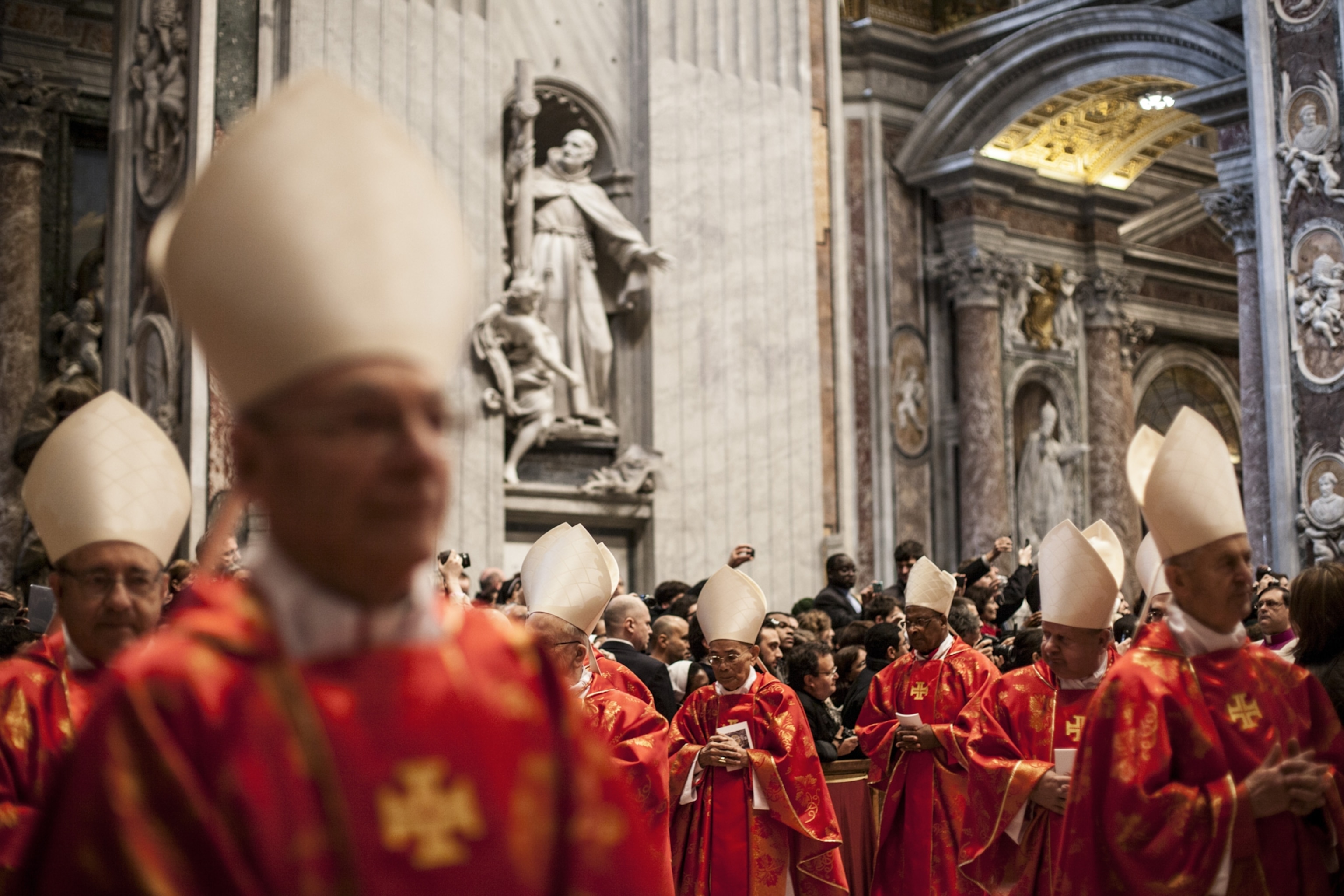 Cardinals are seen standing as they attend mass at St. Peter's Basilica.