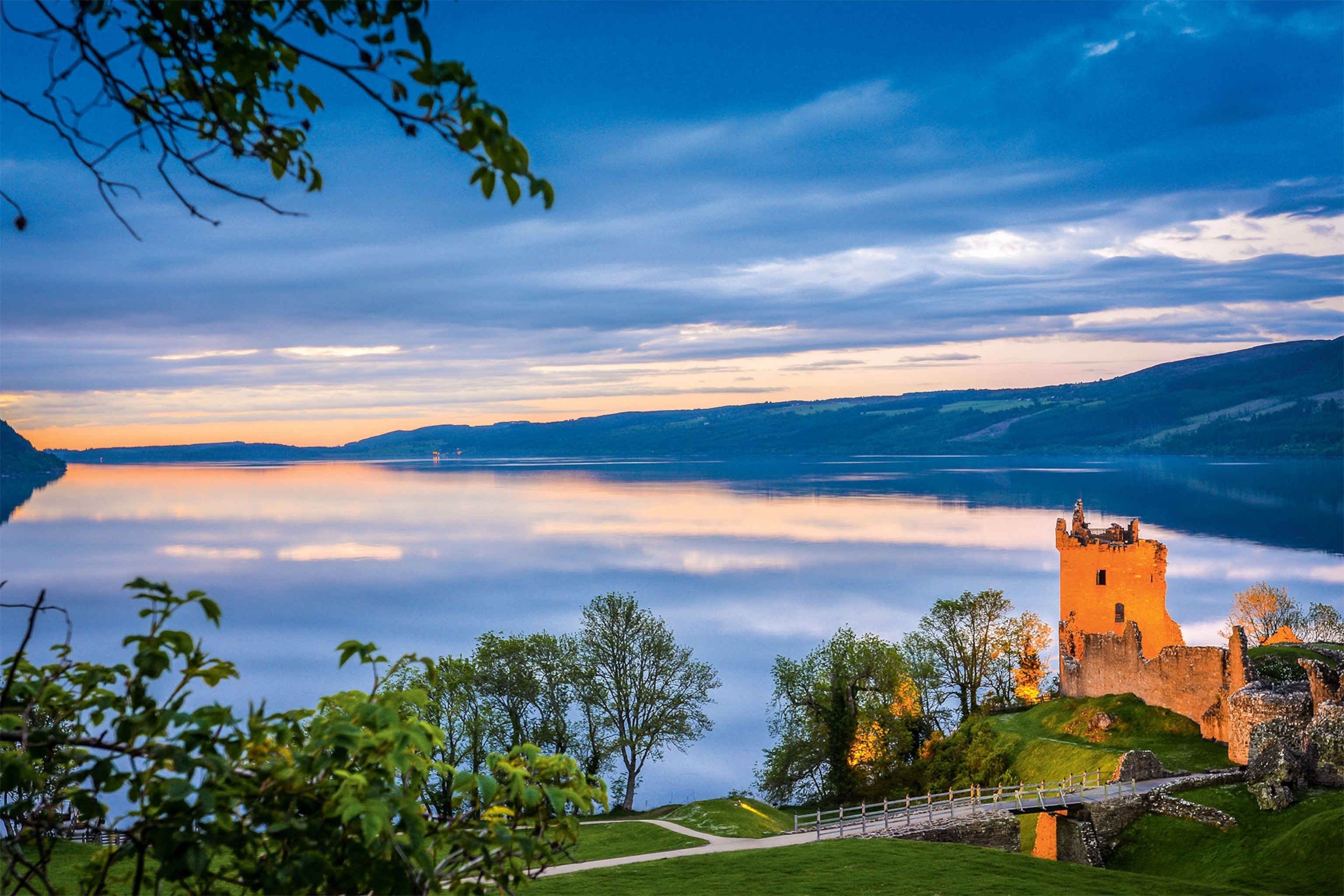 A view of the ruins of a castle with Loch Ness behind it