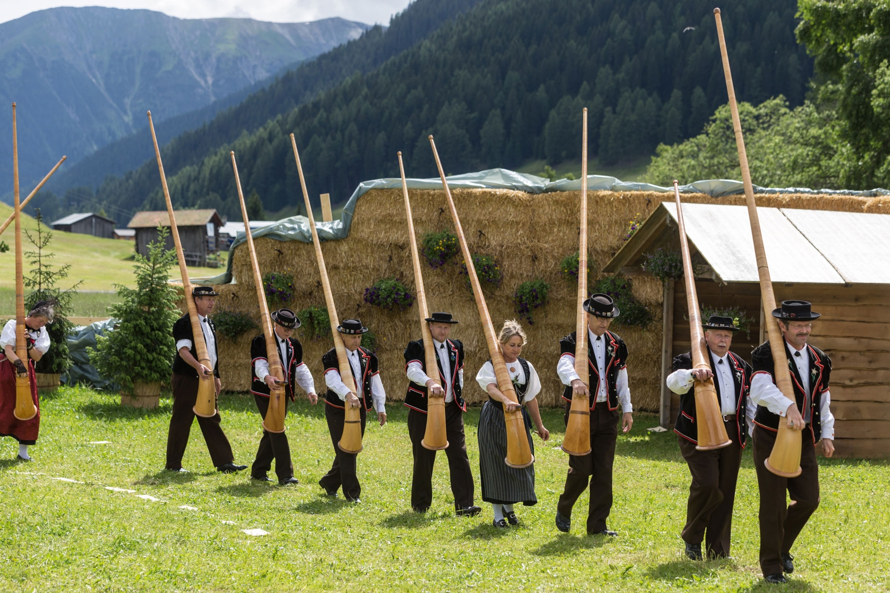 a group of people carrying alphorns