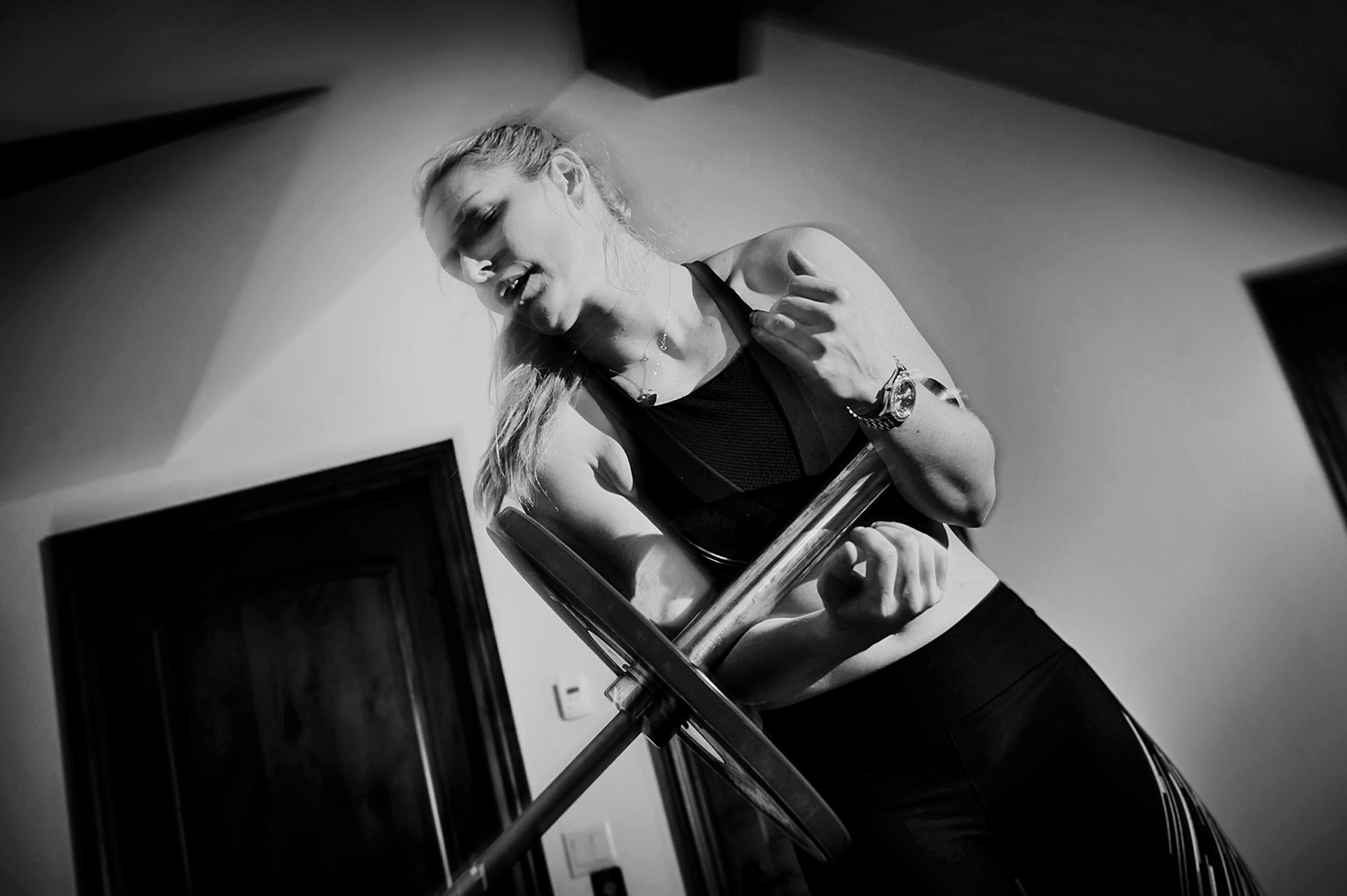 A woman lifts weights in her home.