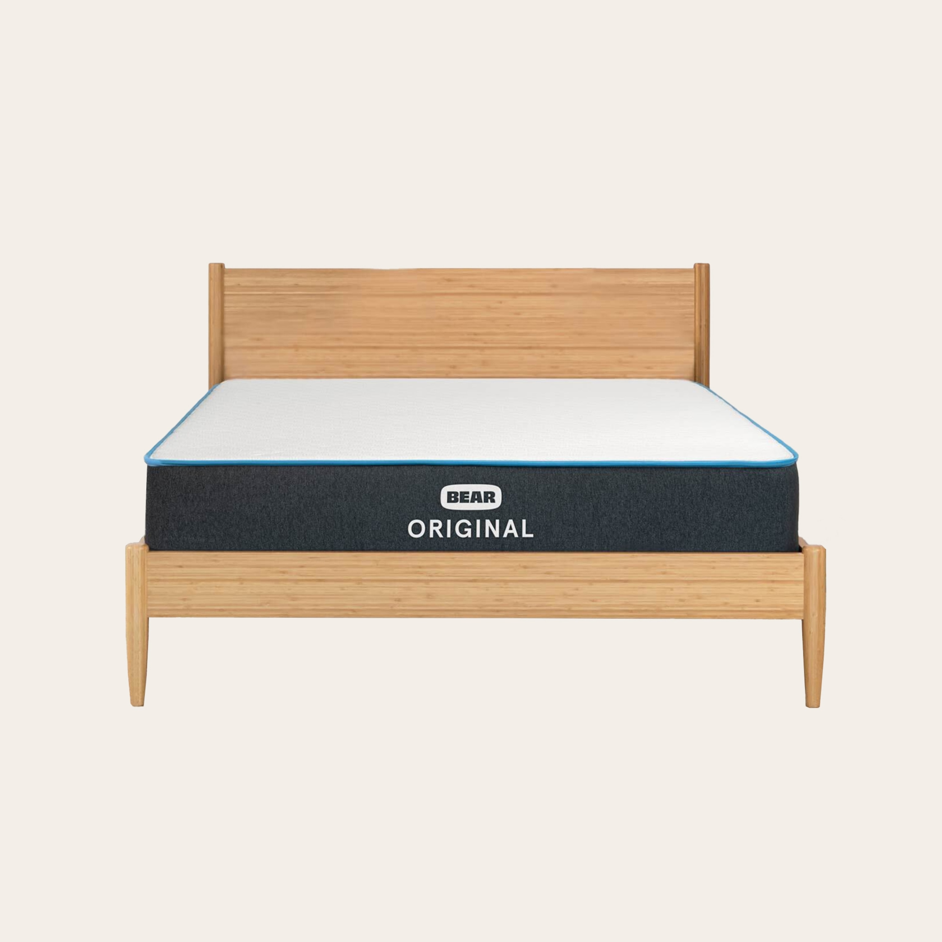 An uncovered mattress on a light wooden frame against a tan background.