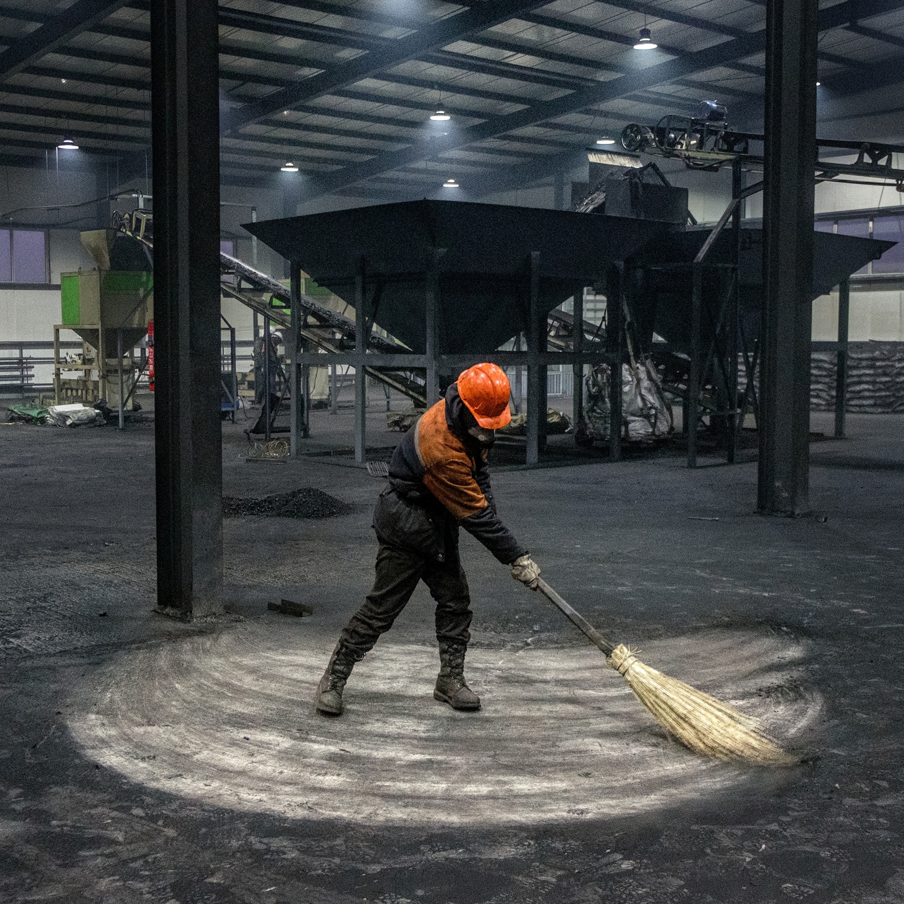 Picture of man sweeping floor with broom.