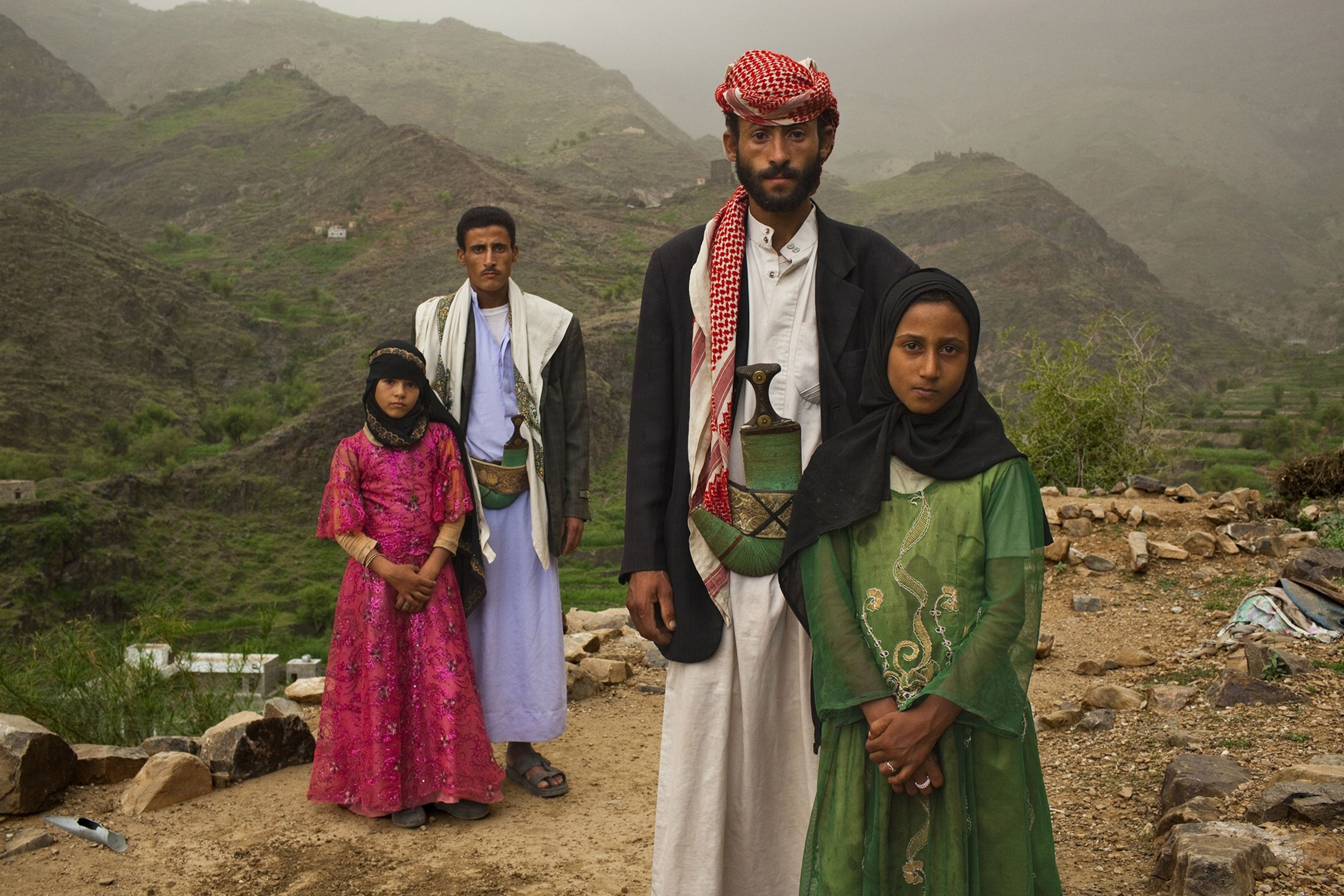 Two child brides with their husbands outside their mountain home