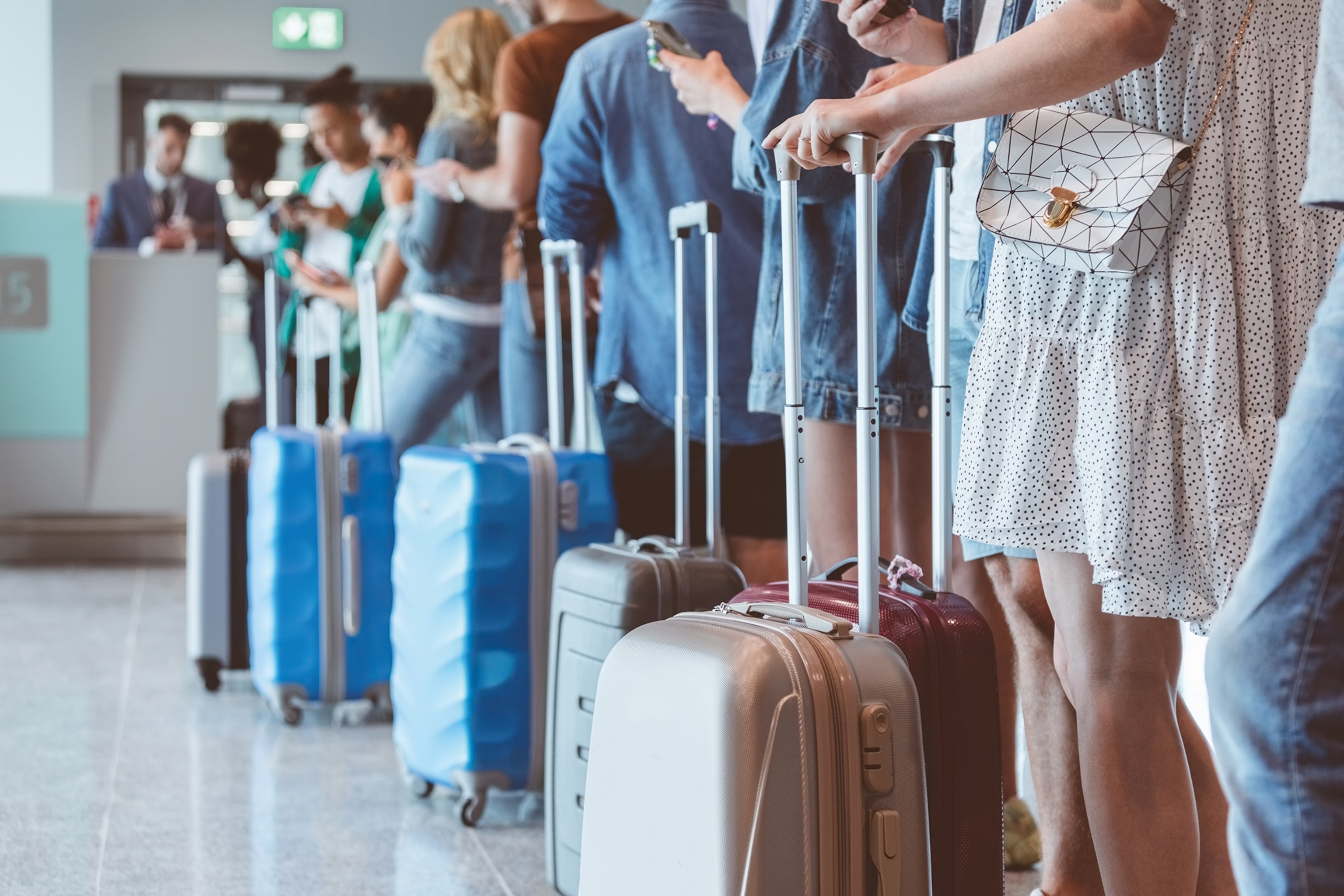 Line of people at an airport with suitcases