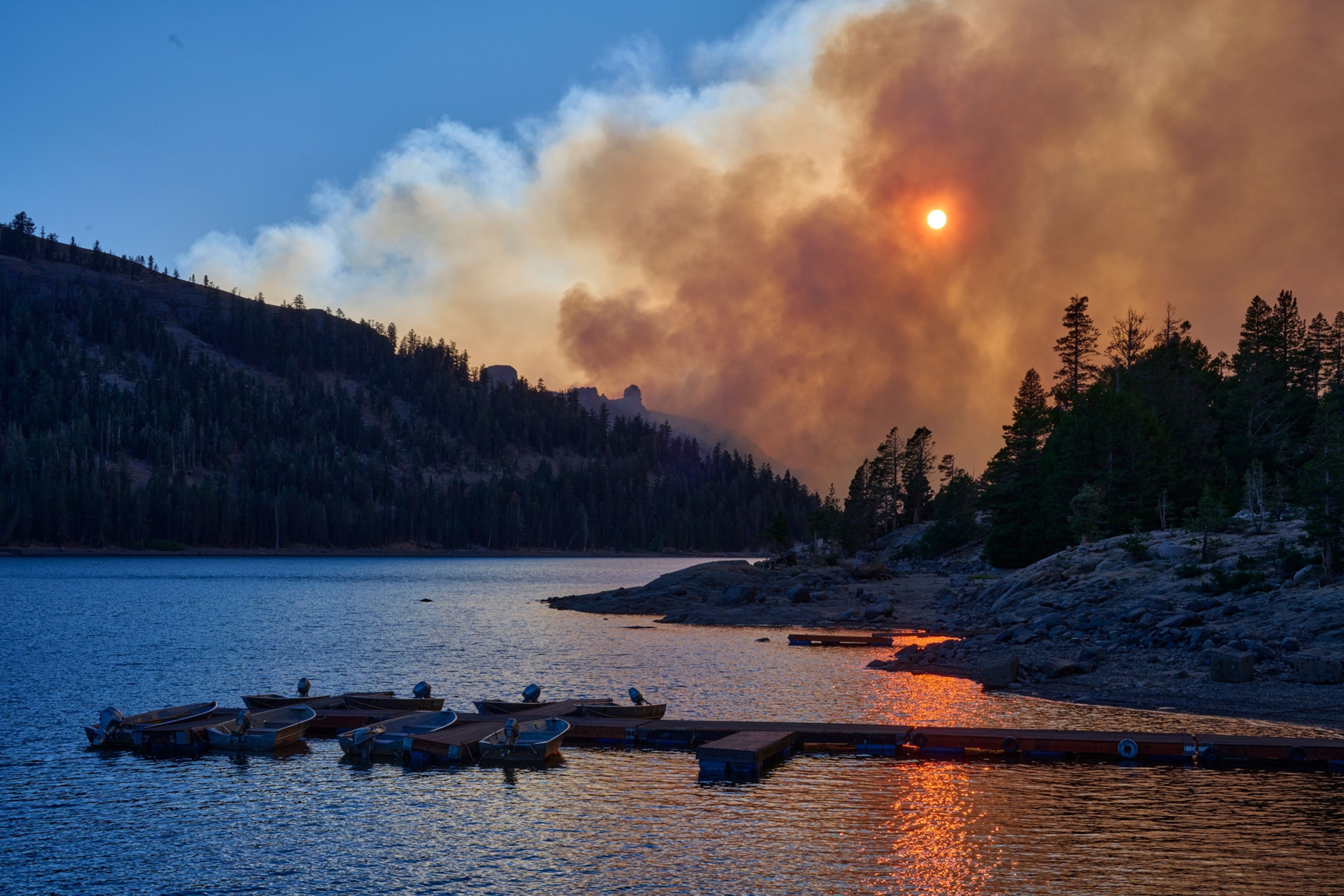 Smoke from the Caldor Fire rises up over the mountains near Caples Lake.