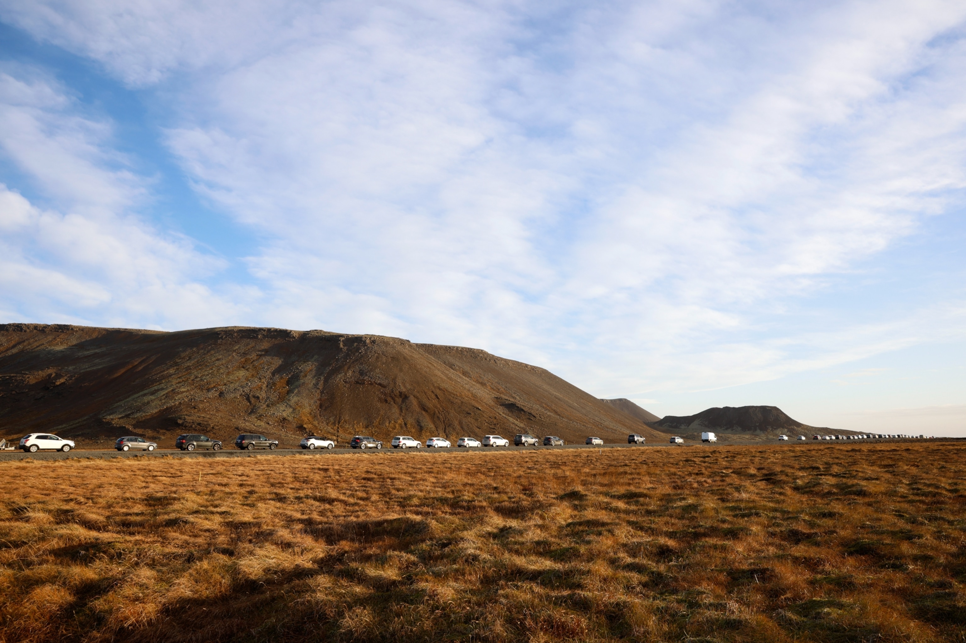 A line of cars queued on a road on the outskirts of Grindavik, Iceland.