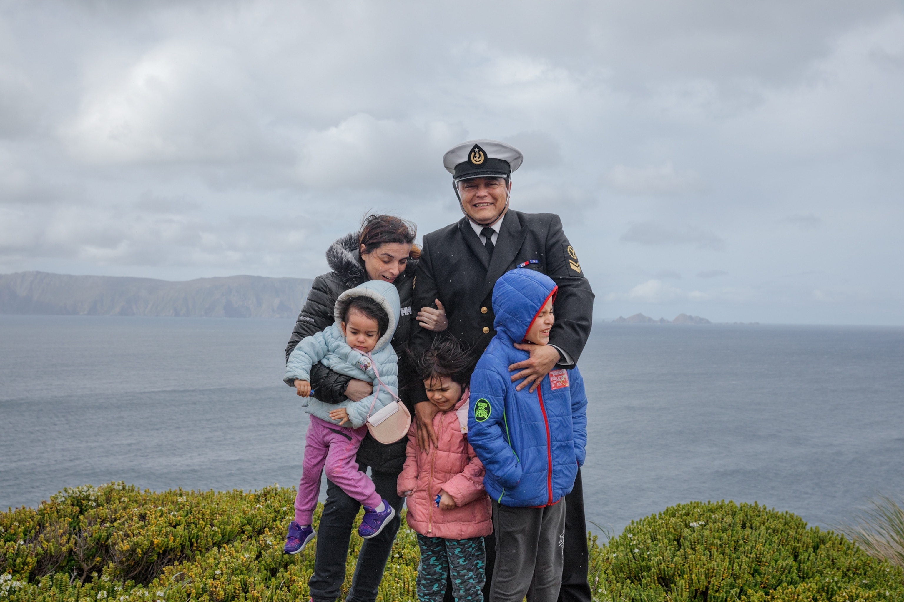 Picture of family with three small children on wet and windy day.