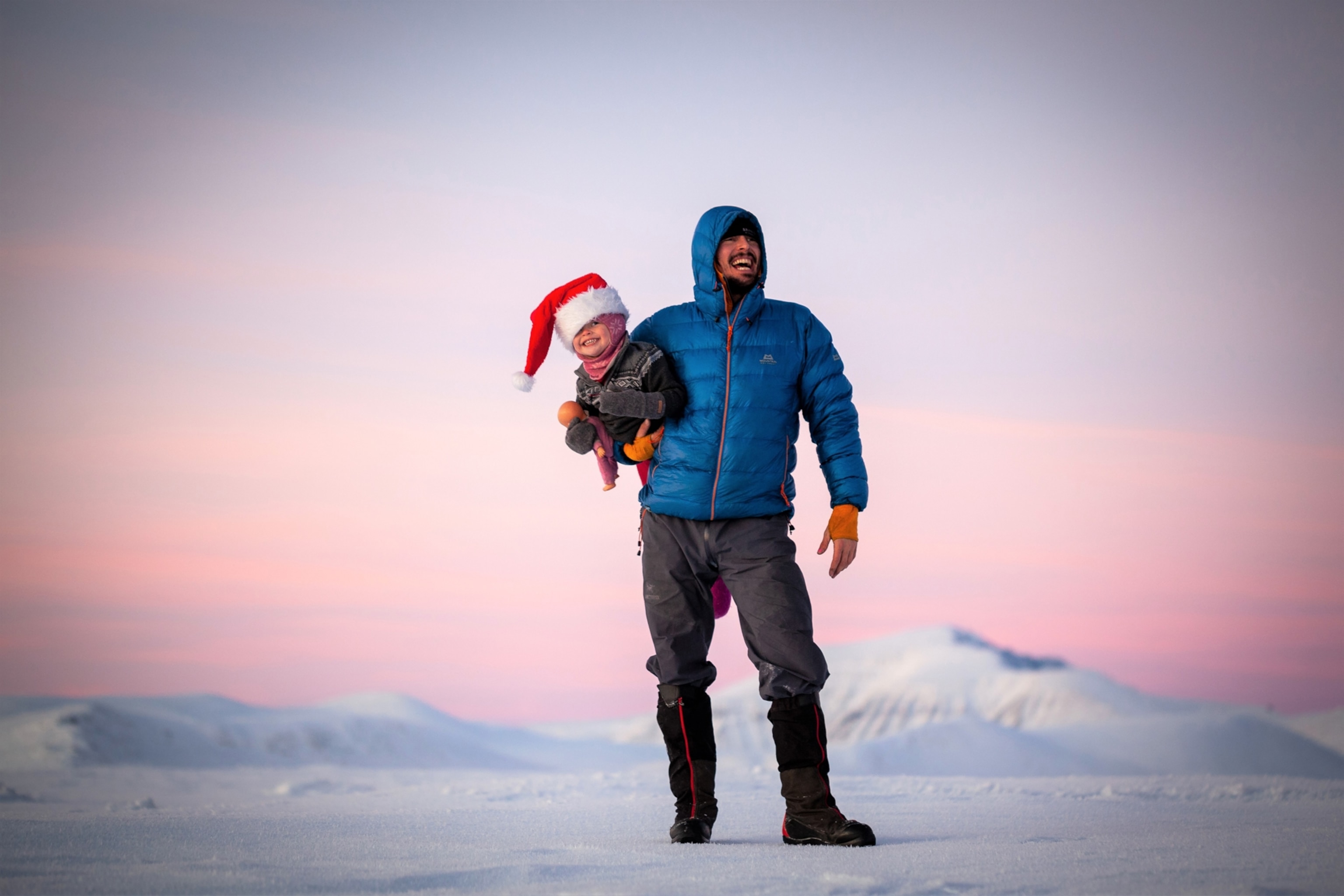 man holding his daughter in winter