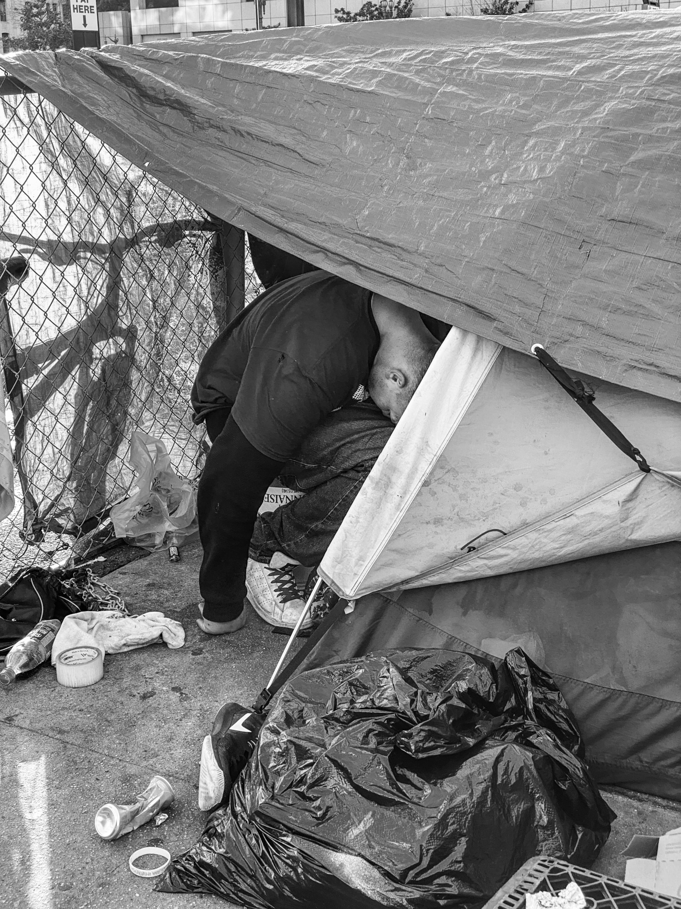 a man hunkered over in a outdoor housing structure