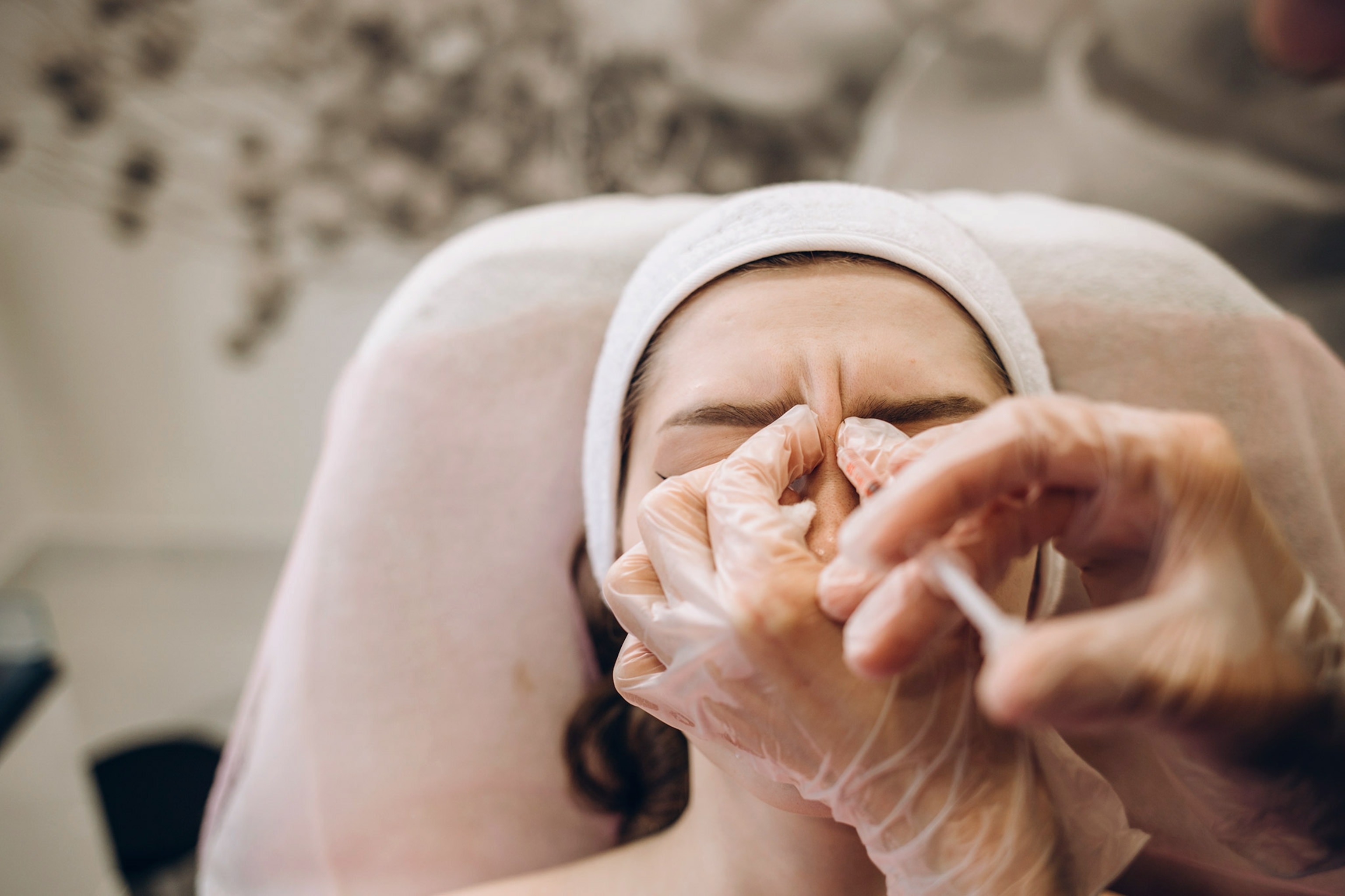 A woman lays down and botox is being added between her eyebrow.
