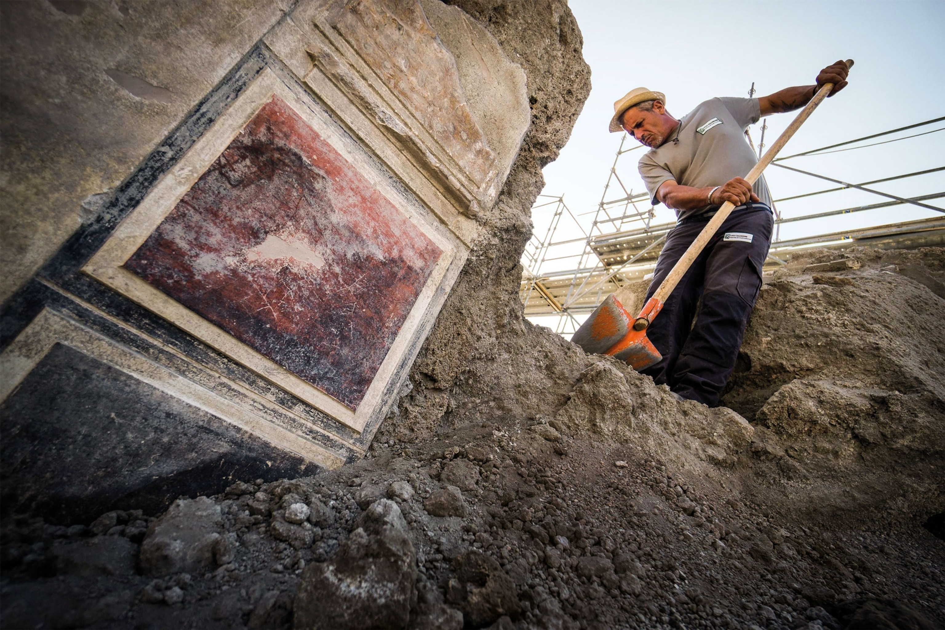 a man using a shovel to dig at an excavation site