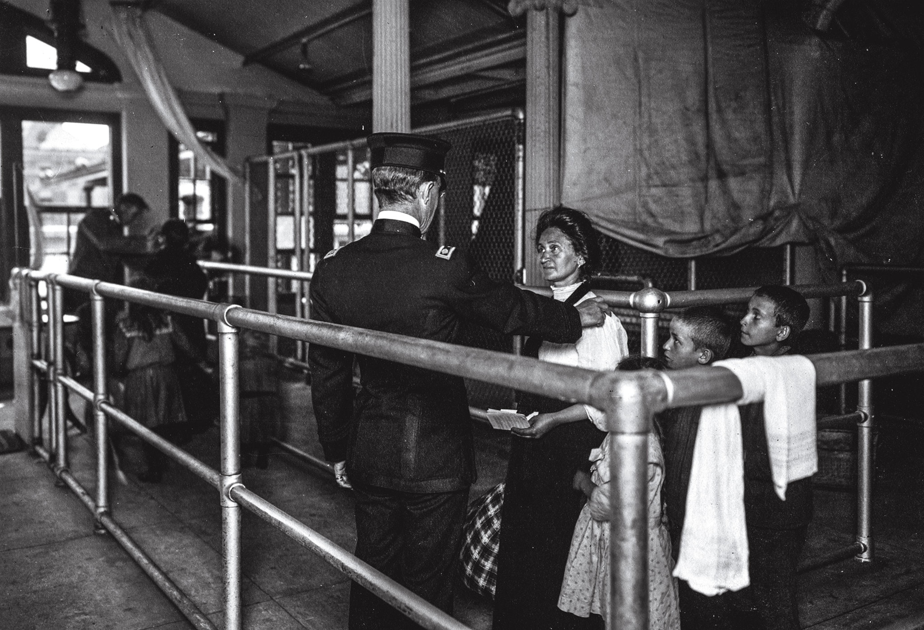A woman and her children are given a medical exam at Ellis Island in this 1907 photograph.