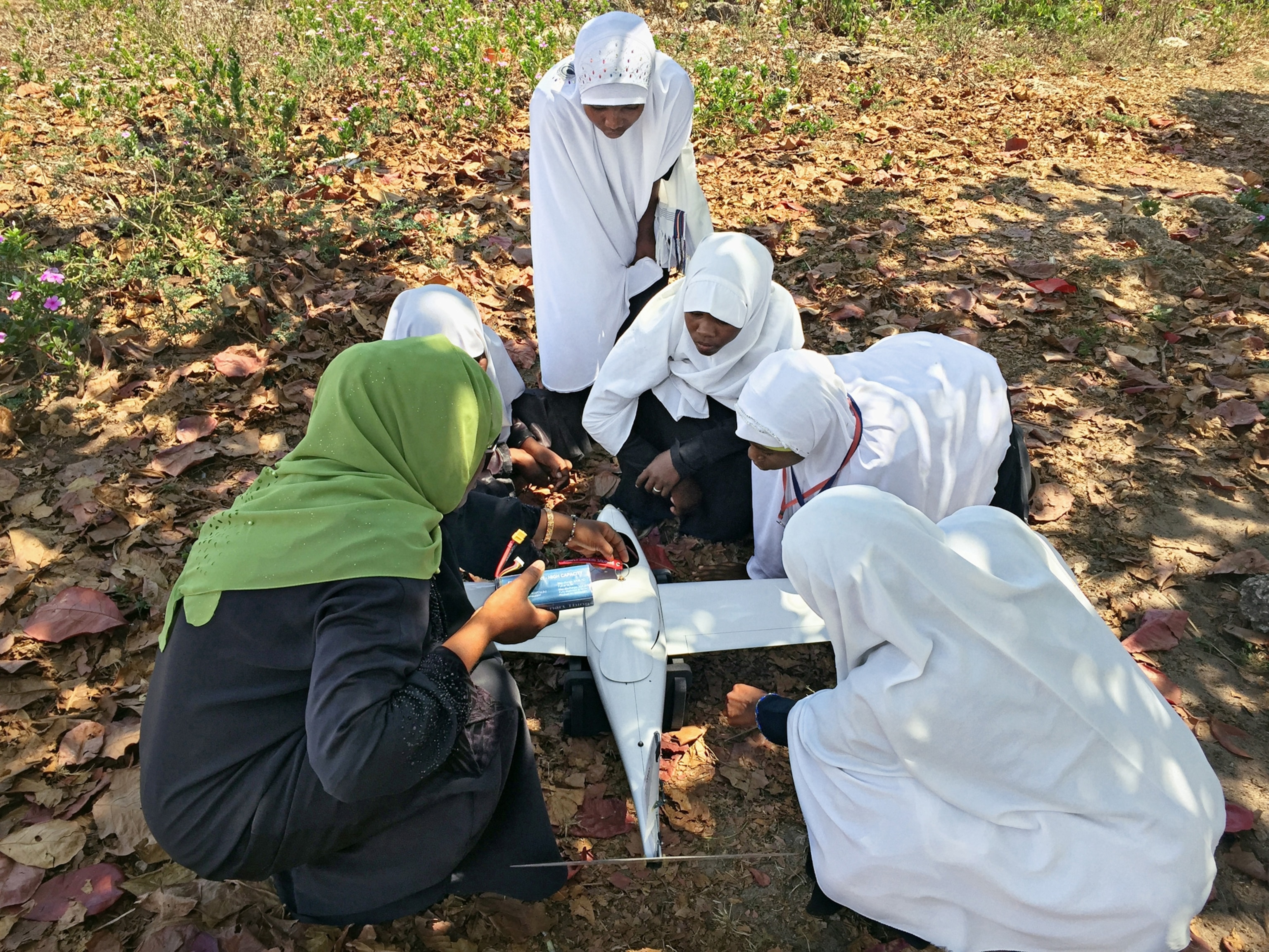 villagers huddling around a drone