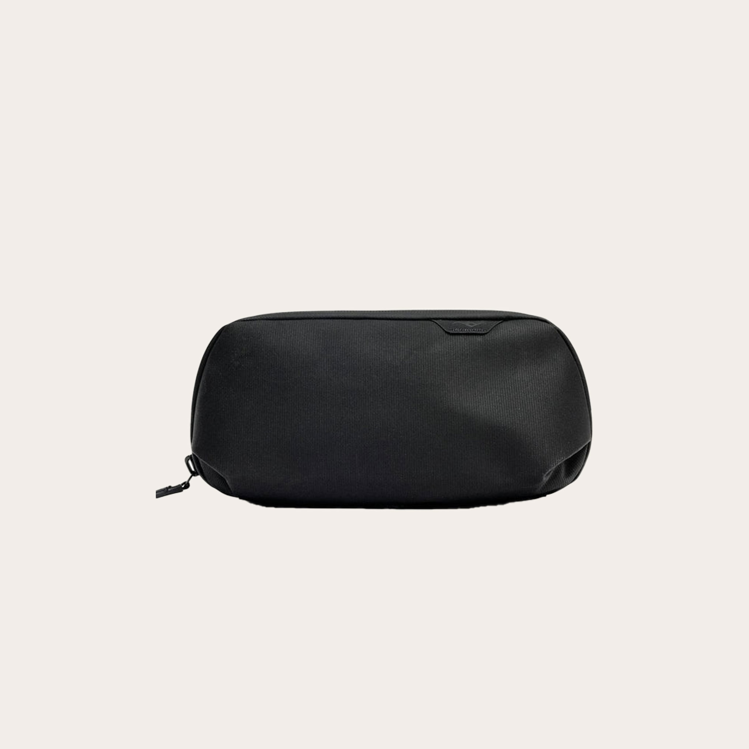 Small black bag placed on a tan background.