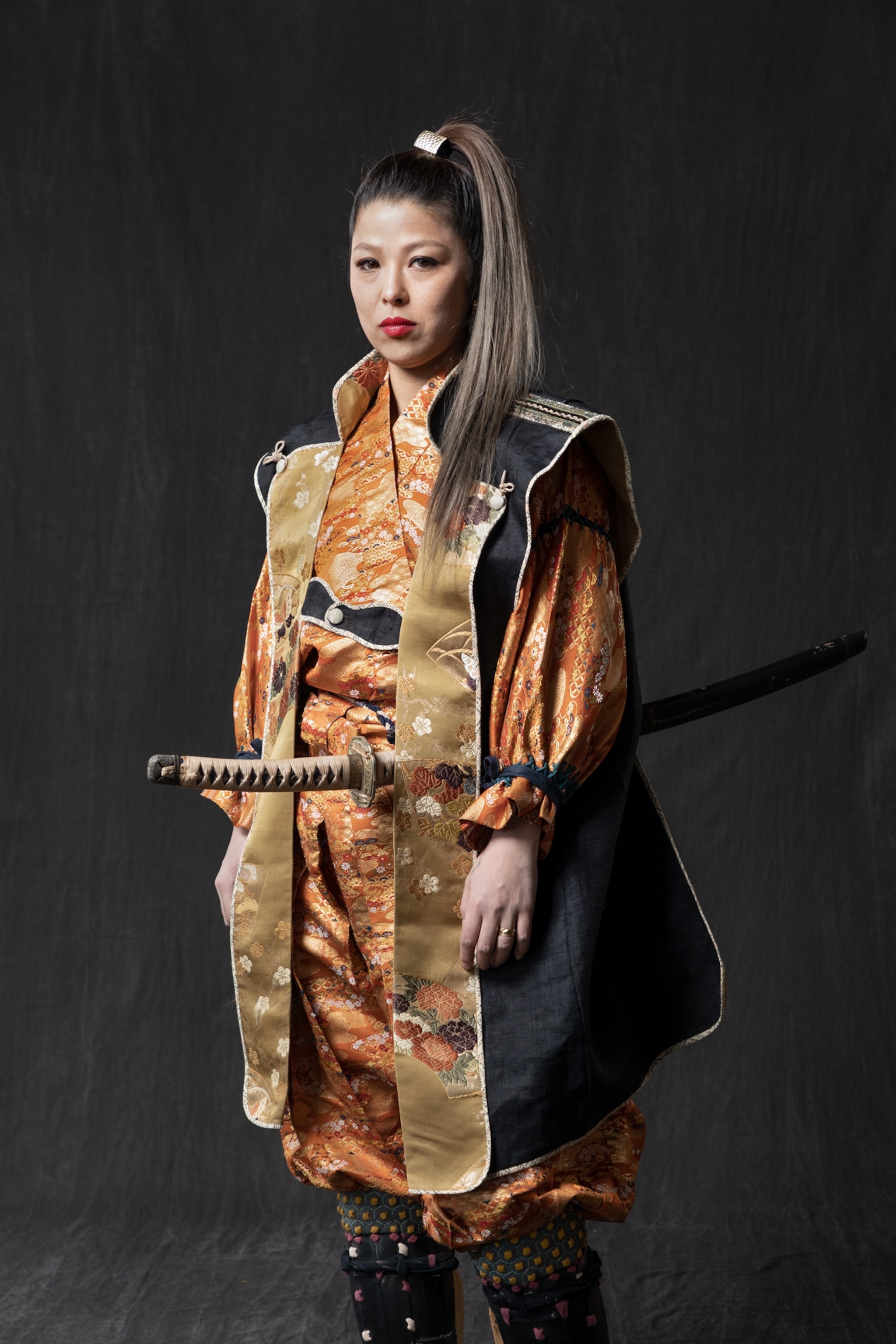 Picture of young woman with long ponytail dressed as a cavalry warrior with long sort.