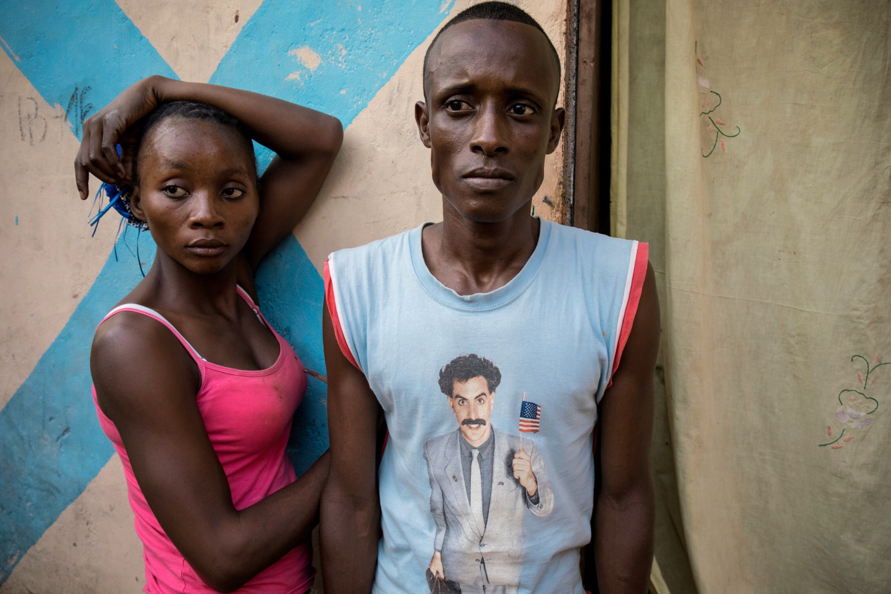 two muslim refugees leaning against a wall