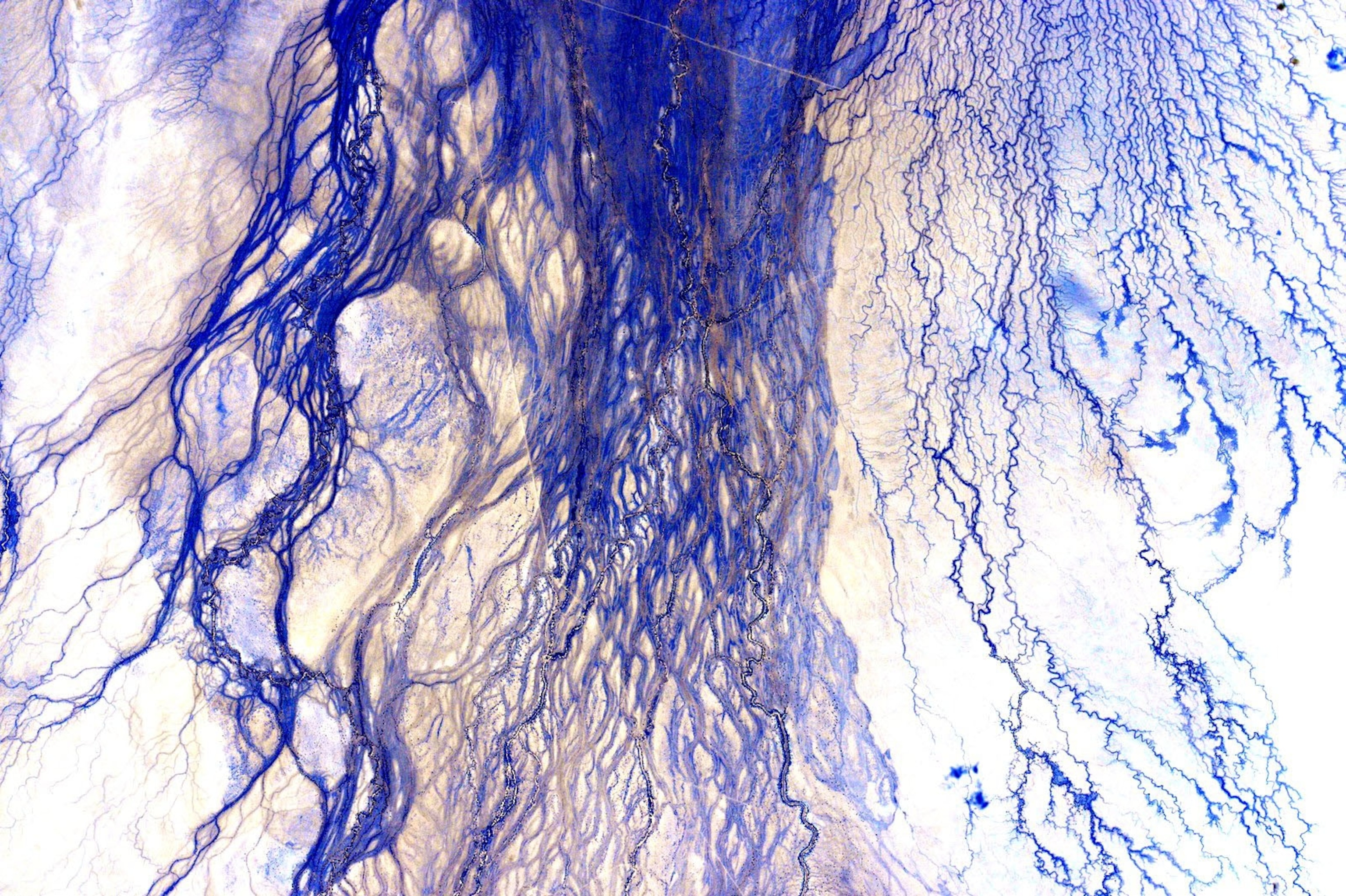 an aerial view of blue streaks amongst a white background