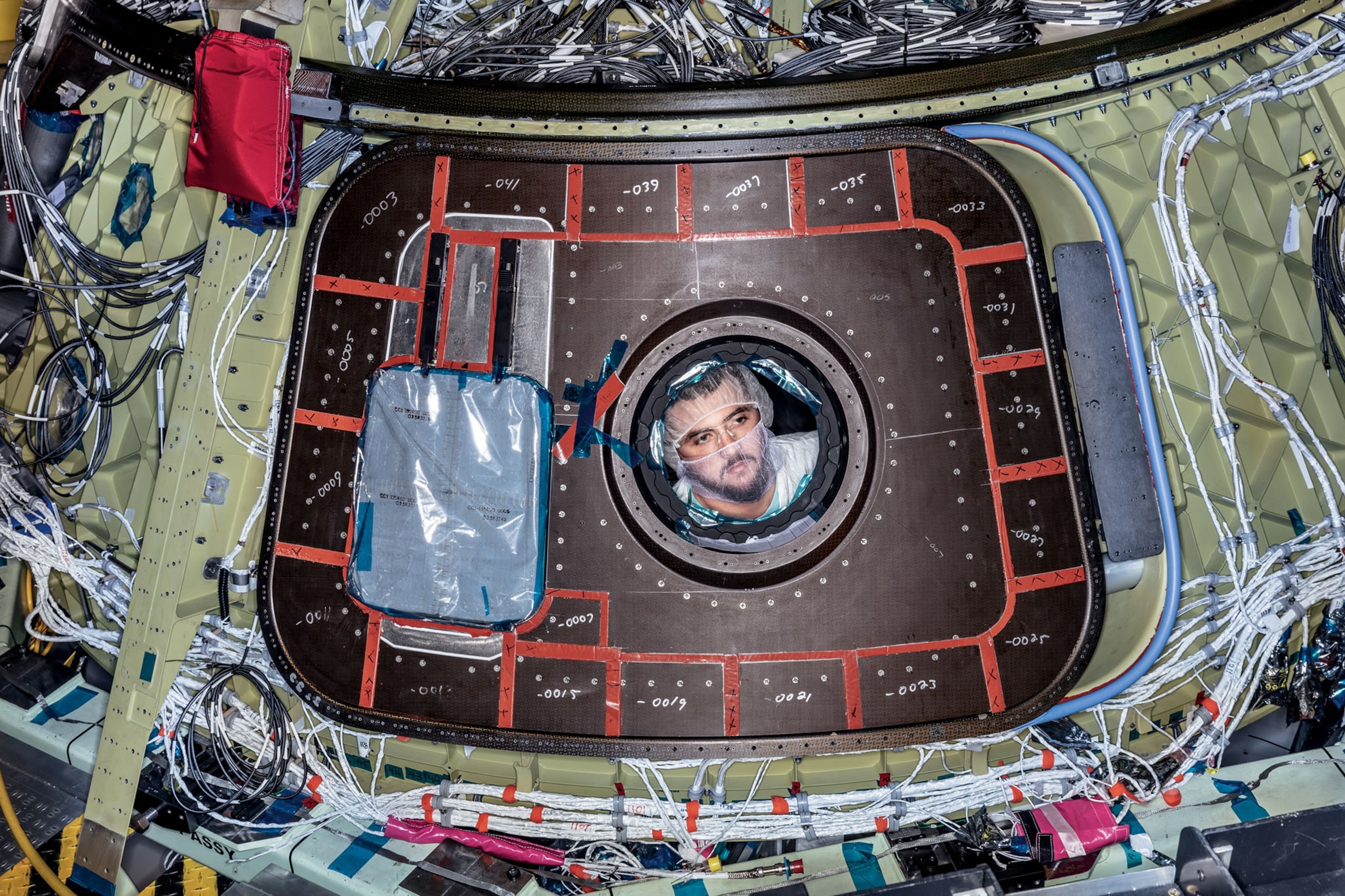 a man looking through the window of a section of a space shuttle