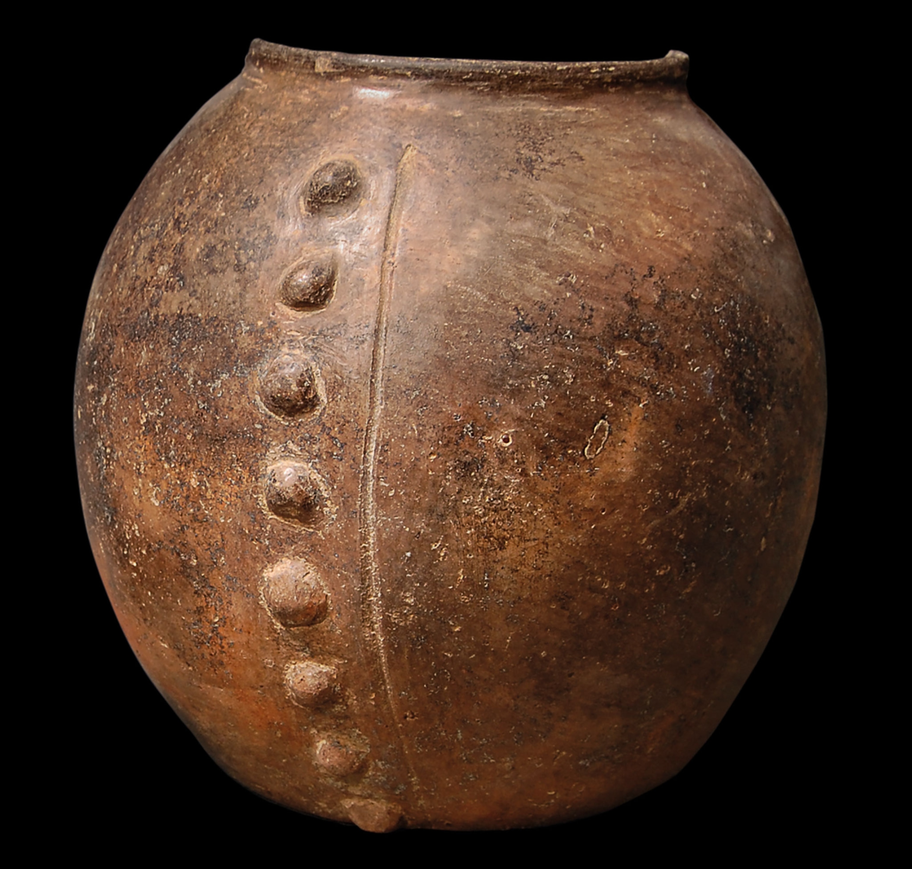 A brown circular vase with a line of bumps