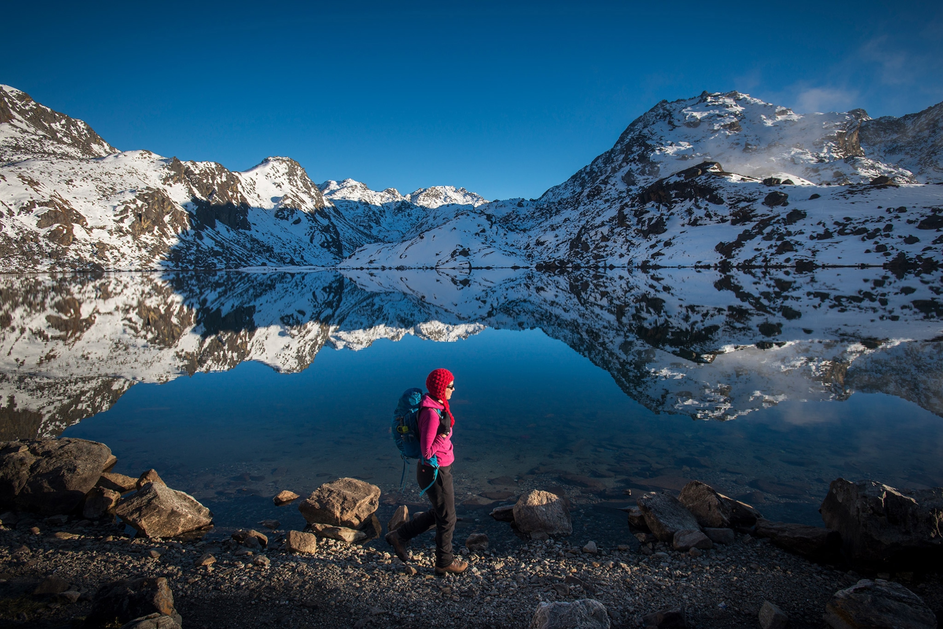 a woman walking past the holy lake of Gosainkund in the Langtang region of Nepal