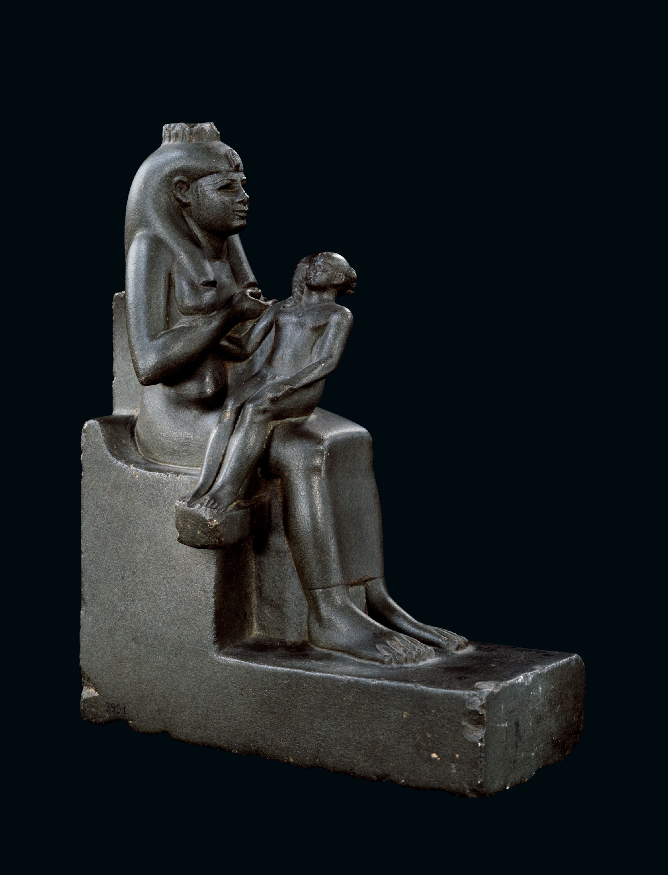 a dark miniature statue of the goddess Isis nursing Horus