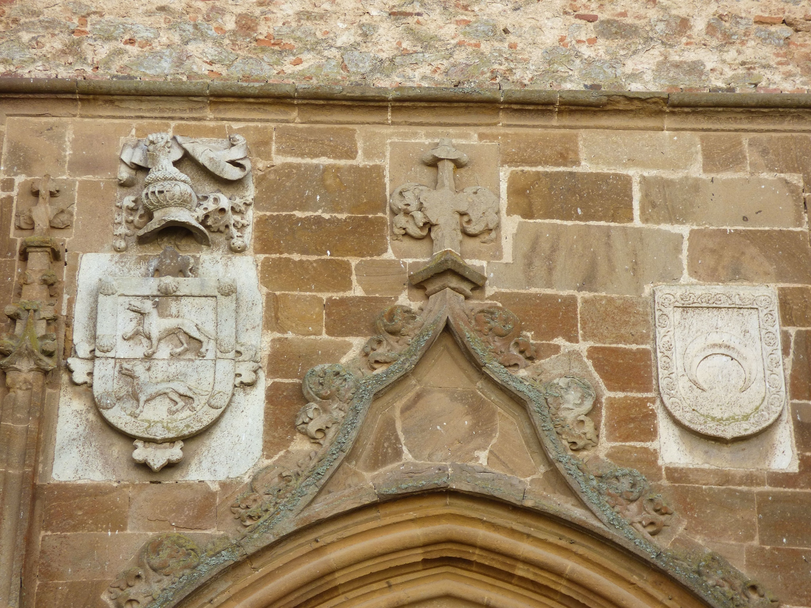 A view of shield carvings on the side of a church wall