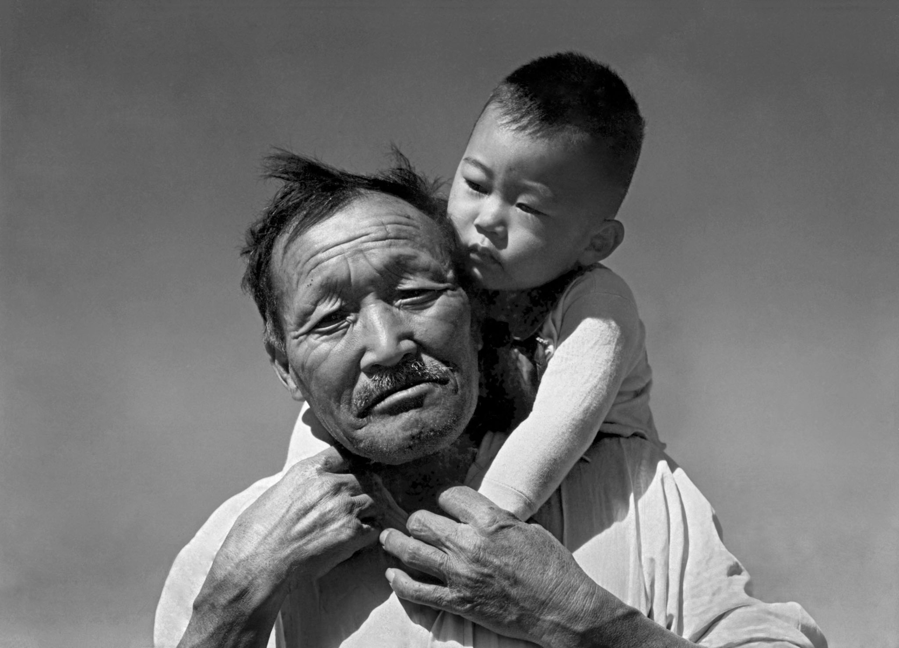 a man holding a baby boy, shot in black and white