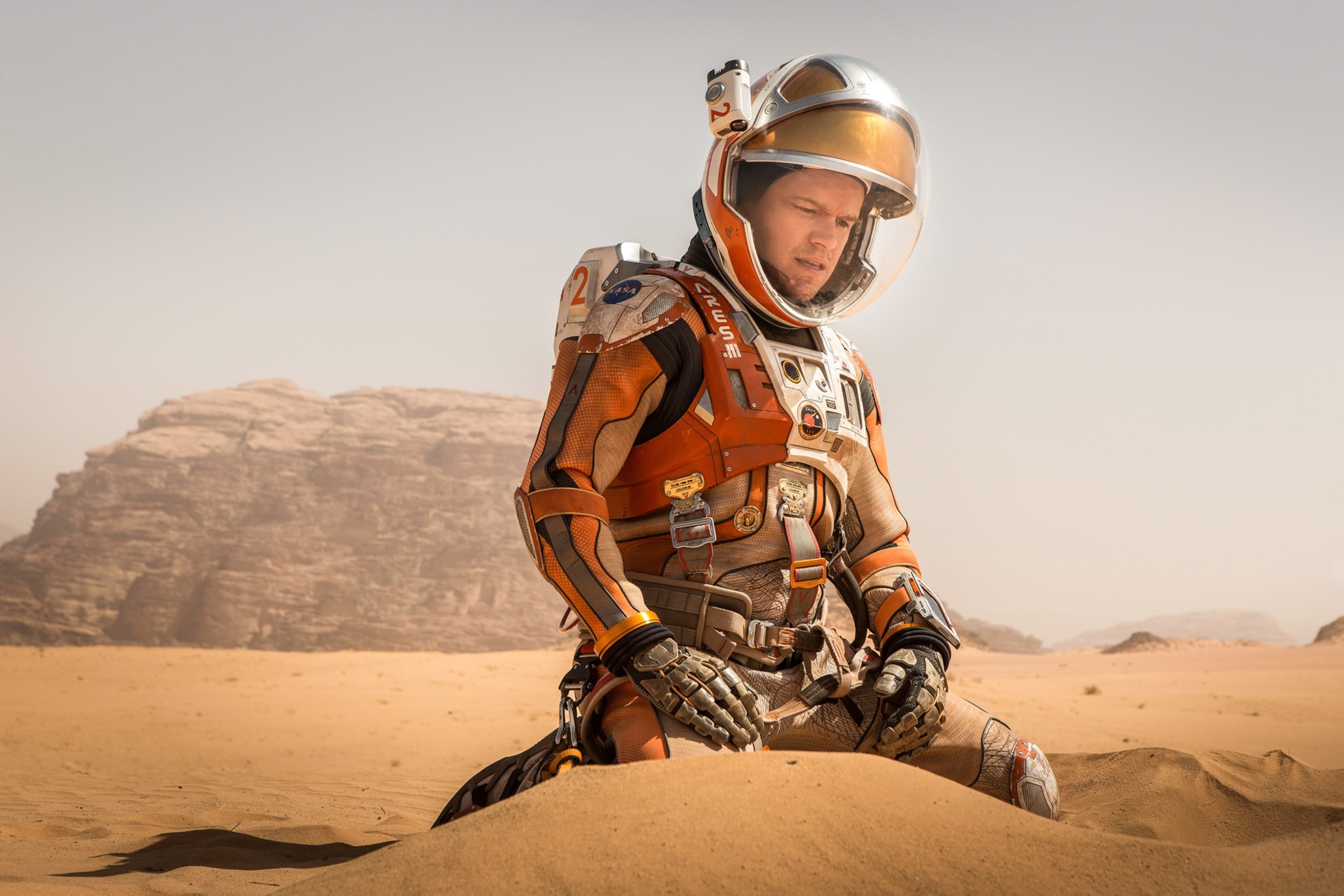 man in space suit sitting on send.