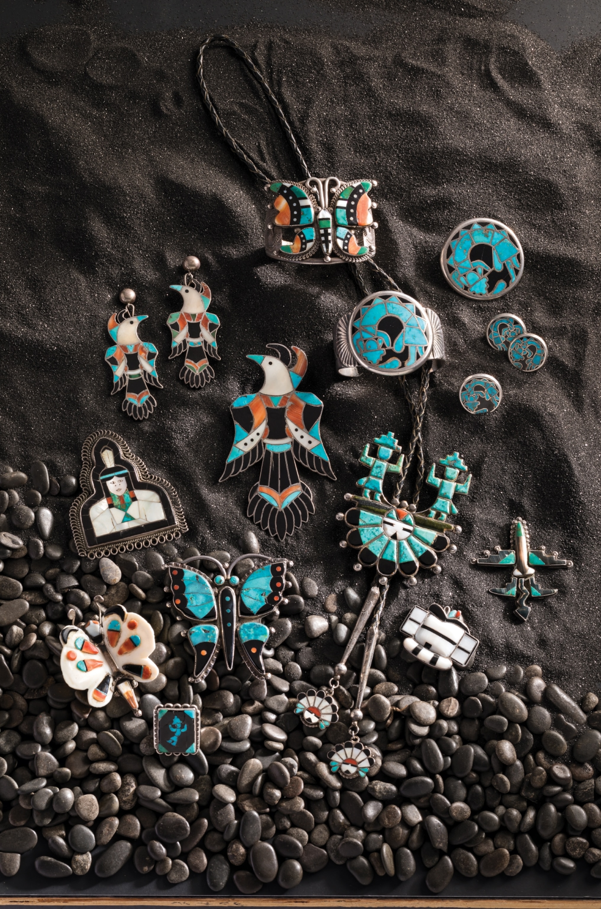 A variety of native turquoise jewlery lay out on small stones