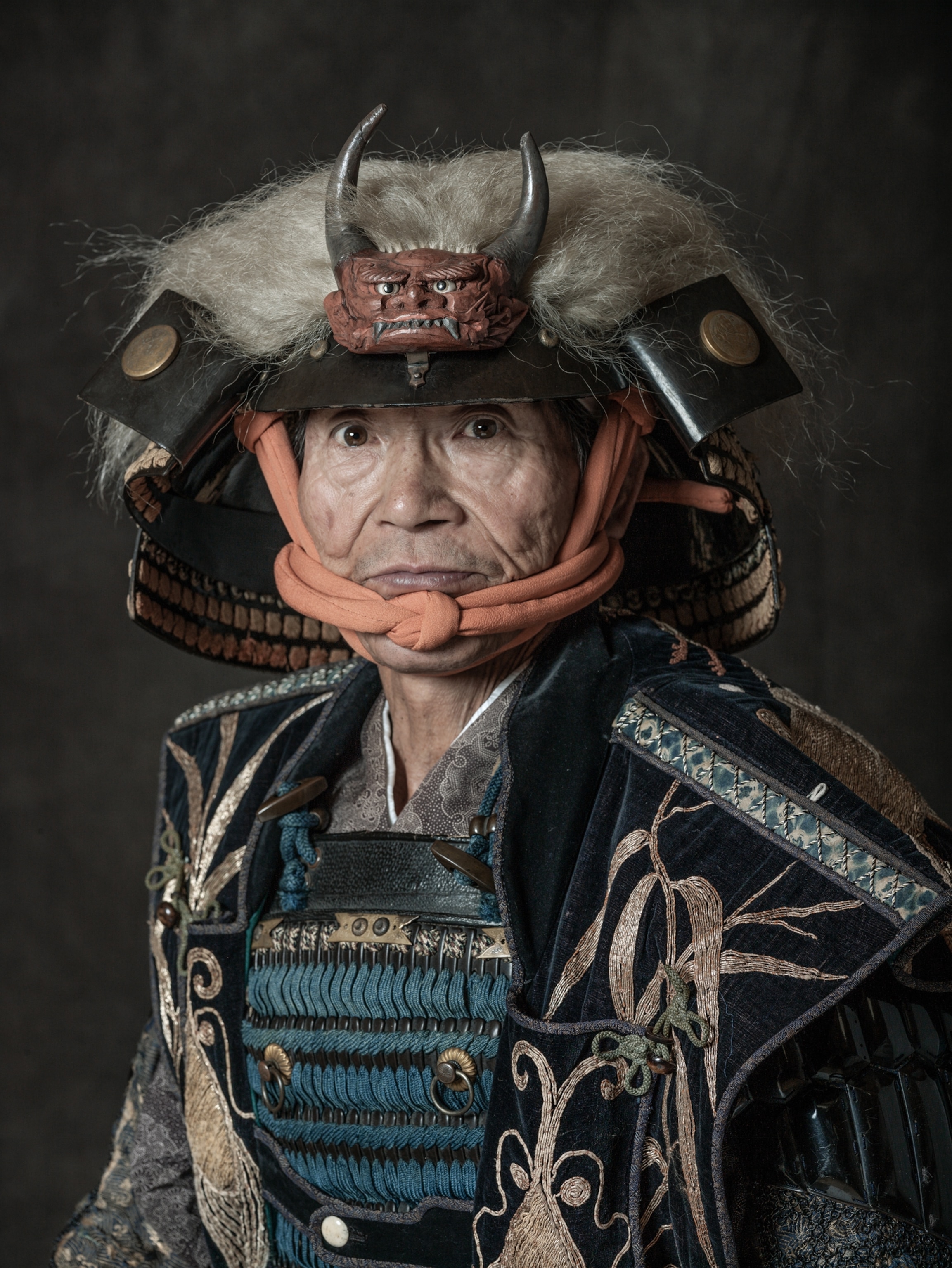 Picture of older man dressed as taisho in hat with horns.