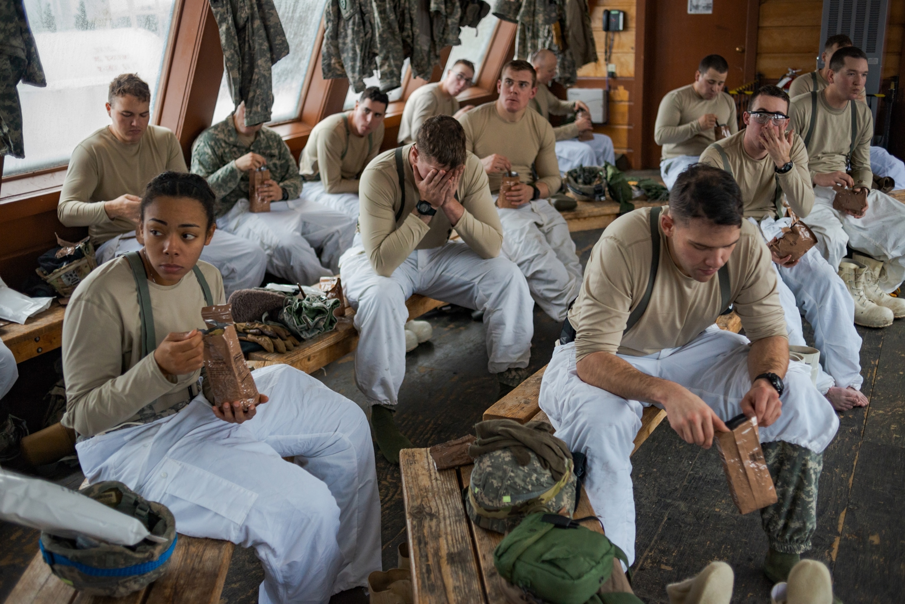 male and female soldiers eating food from brown bags.