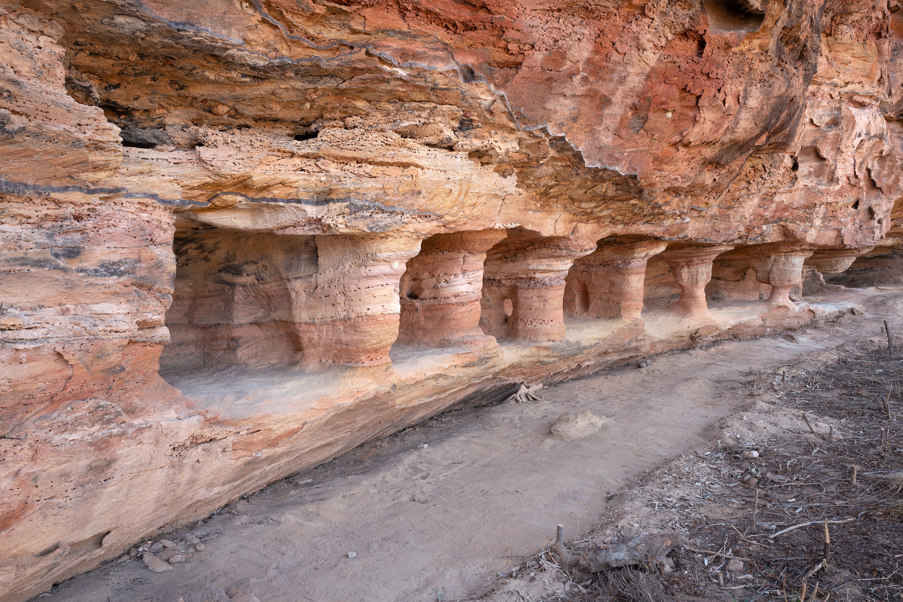 A closer view of the series of quadrangular boxes, like tiny rooms, cut into a sandstone rock face
