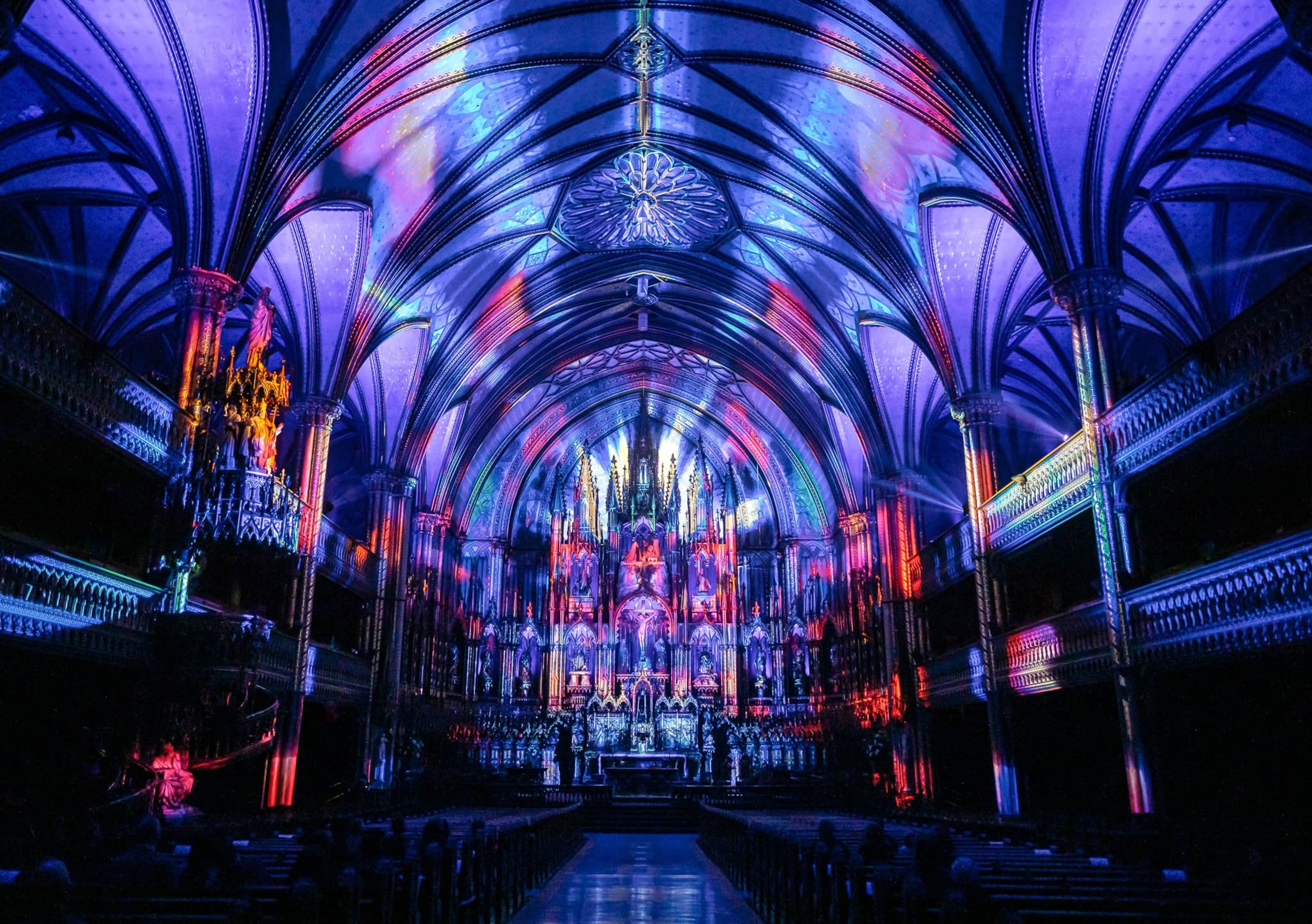 Hues of purple, blue and red reflect patters inside of a curch.