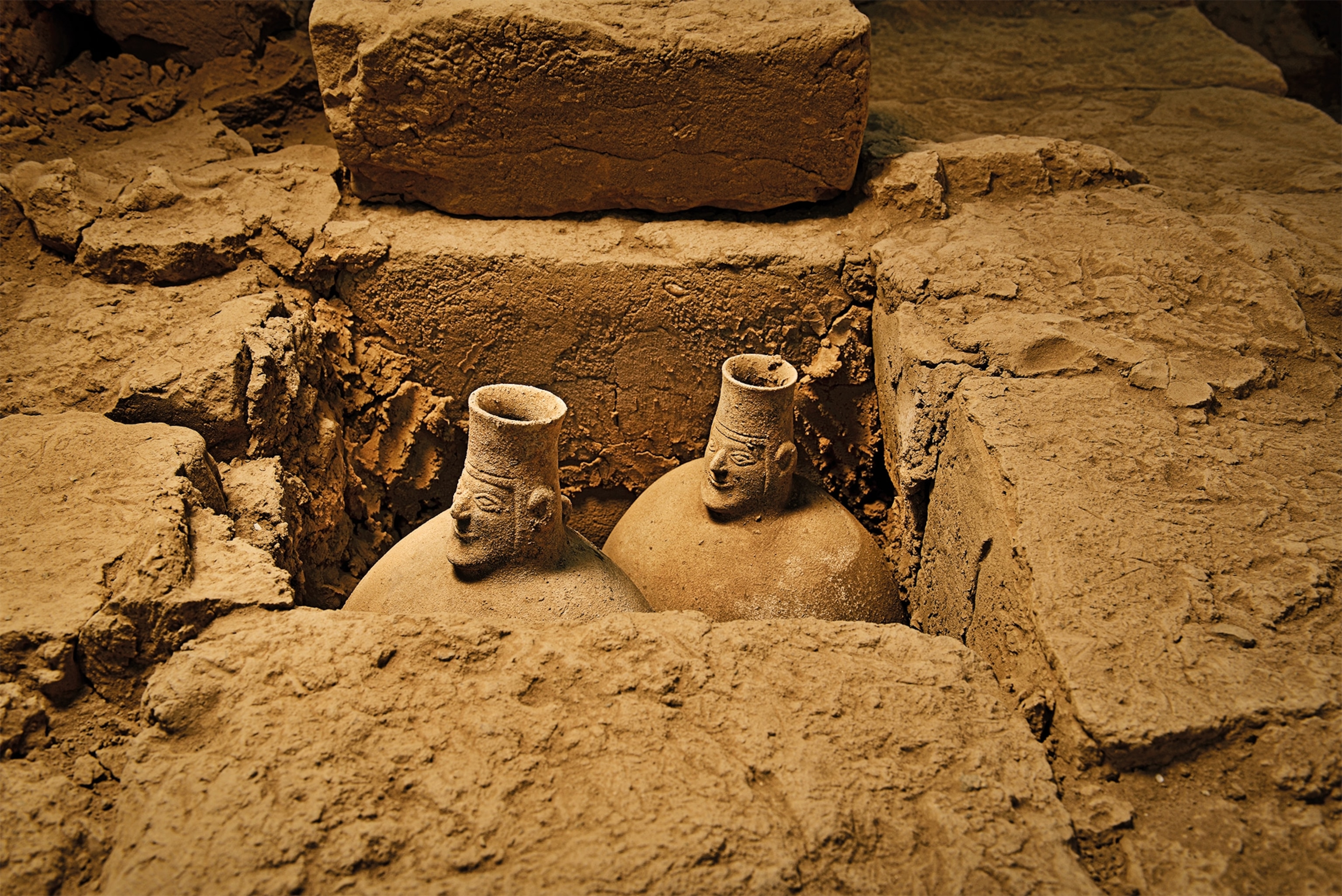 Two ceramic jars, adorned with smiling faces (above), were among more than a thousand artifacts recovered from the tomb at El Castillo.