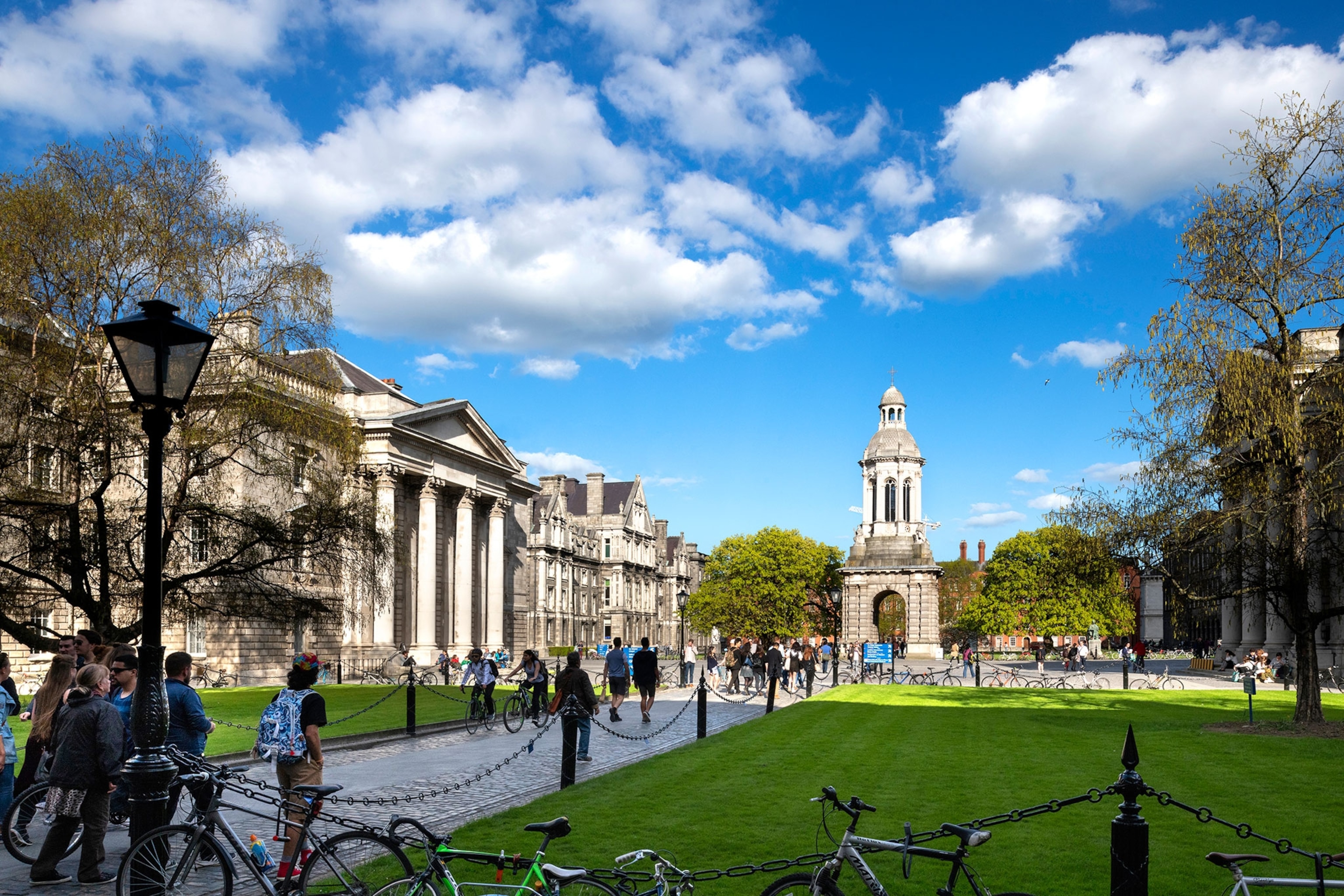 Trinity College campus buildings in city center with tourists.