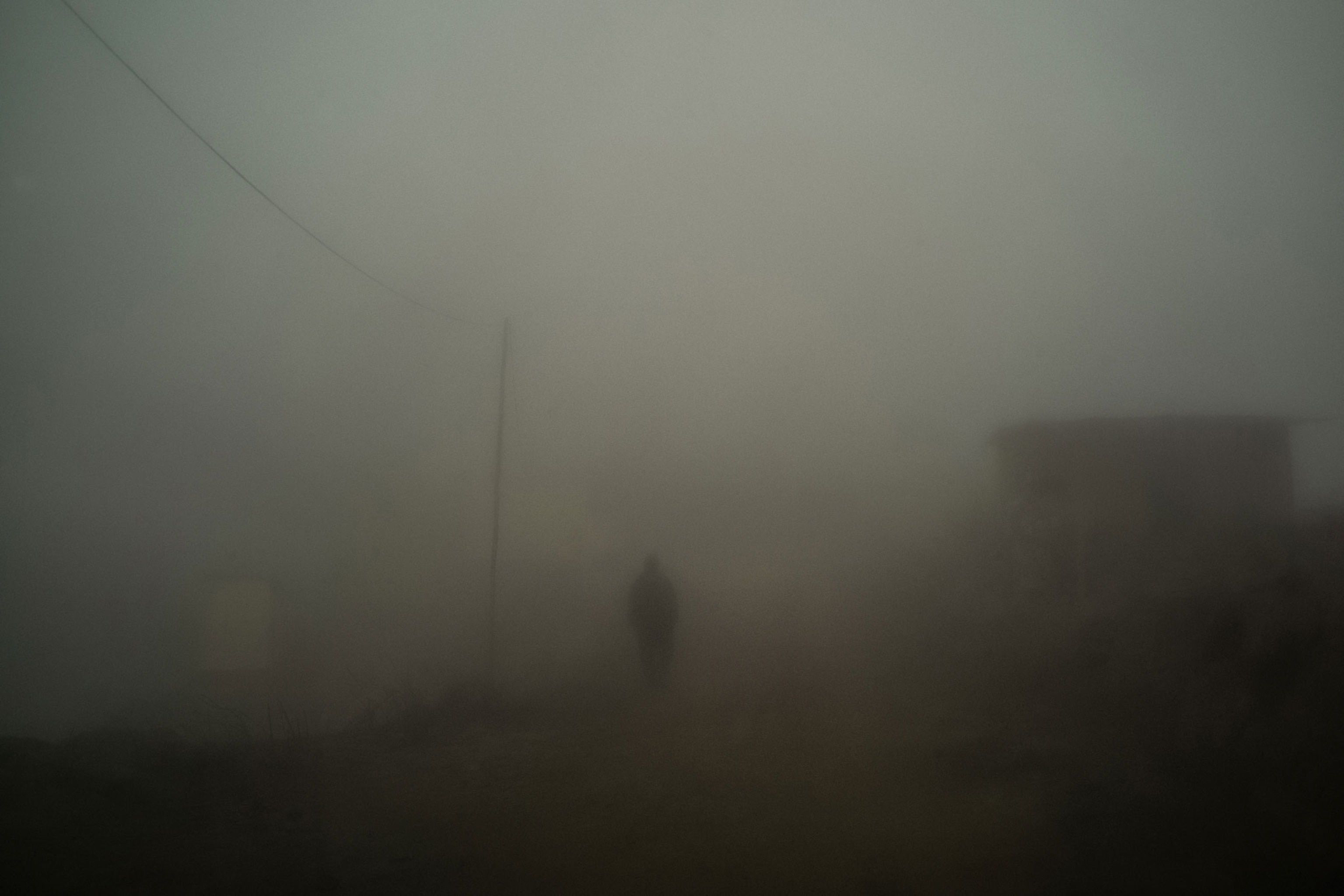 a man walks through thick fog